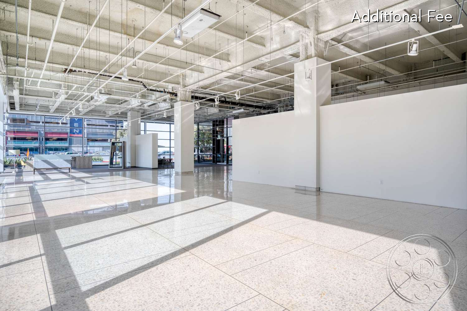 SKYstudio® - large windows, white walls, concrete ceiling, natural light, neutral color palette, modern architecture, open layout, minimalist design, ambient lighting, flexible space, industrial style, urban environment, commercial space, polished terrazzo flooring, reflection on flooring, unfinished aesthetic