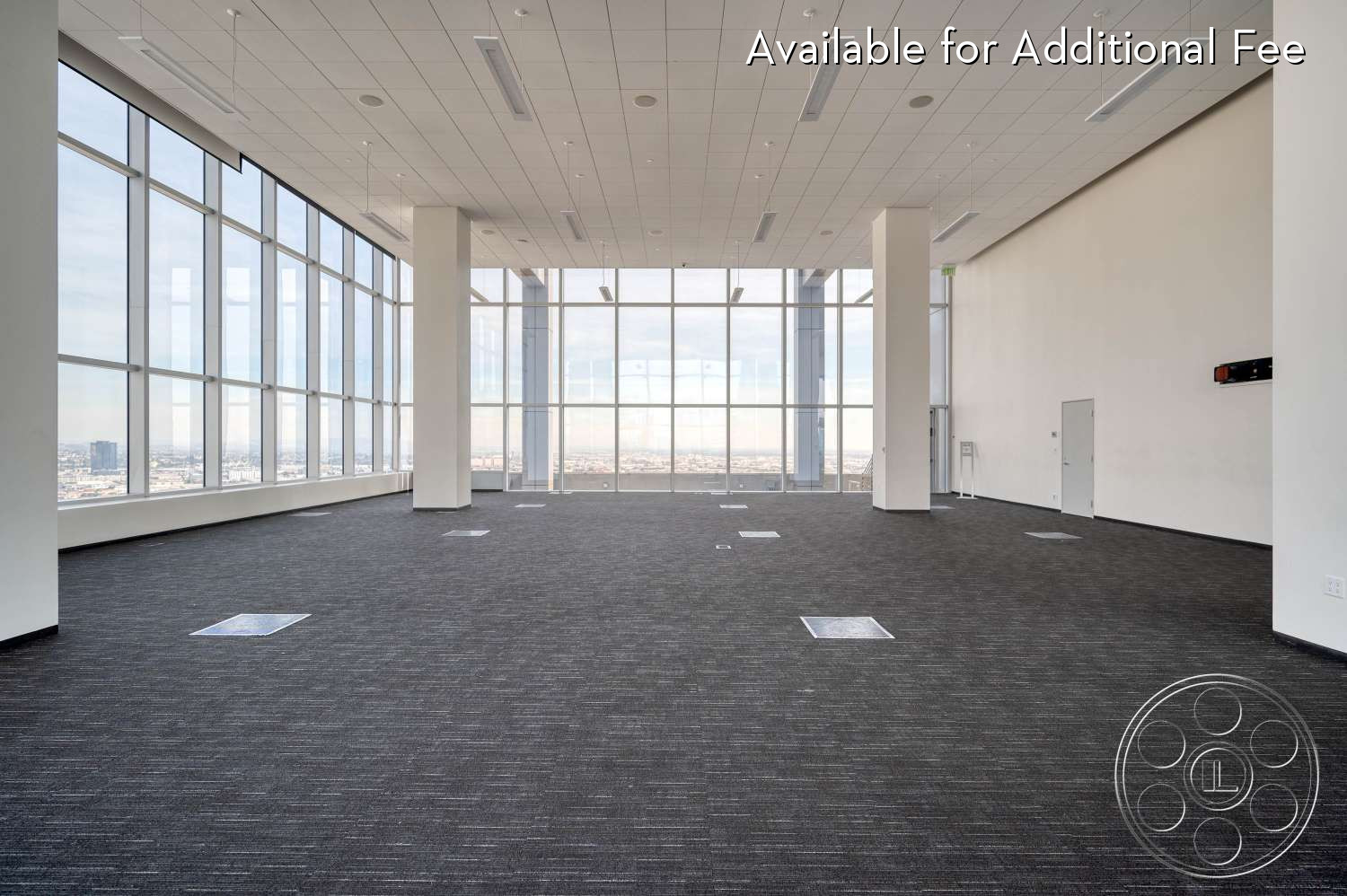 SKYstudio® - city view, large windows, modern, open space, high ceilings, event space, minimalist, light gray walls, contemporary, urban setting, ambient lighting, creative workspace, flexible layout, business environment, commercial space, neutral wall color, professional setting, dark gray carpet, suspended lights, corporate office