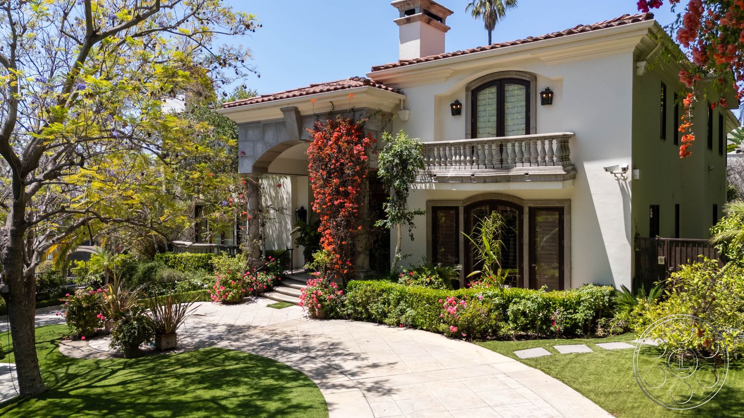 Medit 165 - balcony, outdoor lighting, exterior, Mediterranean architecture, lush greenery, tropical plants, modern landscaping, inviting outdoor space, private residence, curved driveway, wooden windows, landscaped lawn, elegant entryway, colorful flowers, stucco exterior, ambient lighting features, arched entrance, stone columns, paver walkway, vibrant flower color