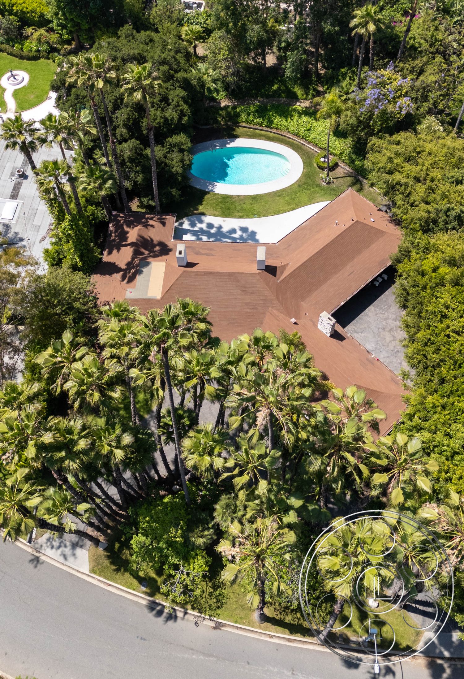 MCM 23 - natural light, exterior, landscaped garden, Mid-Century Modern, residential, modern architecture, flat roof, palm trees, open layout, serene atmosphere, wooden deck, patio, pool, green foliage, outdoor living space, concrete driveway, lush vegetation, tropical setting, private yard, luxury outdoor space, vacation home, brown roof, distinctive chimney, swimming pool area, circular pool, curved paths
