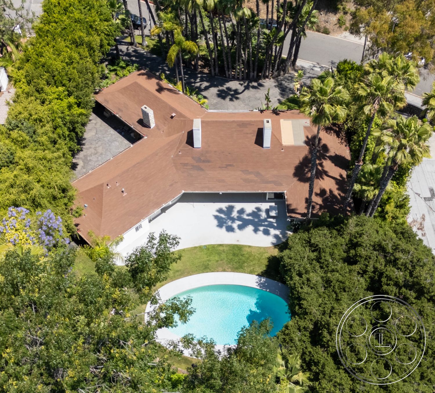 MCM 23 - natural light, exterior, green grass, Mid-Century Modern, residential, outdoor space, lush greenery, driveway, palm trees, modern design elements, concrete patio, aerial view, urban oasis, tropical landscaping, serene environment, brown shingle roof, single-family home, poolside area, quiet neighborhood, white pool, round swimming pool