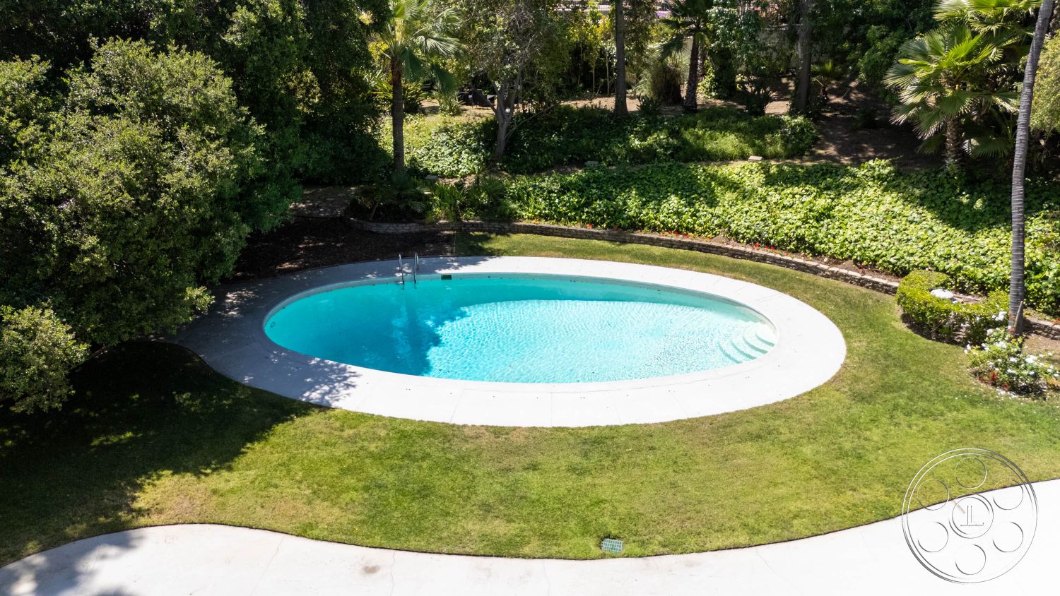 MCM 23 - natural light, exterior, green grass, outdoor space, modern architecture, lush greenery, palm trees, scenic view, tranquil setting, tropical plants, swimming pool, lush landscaping, poolside, relaxing atmosphere, vibrant foliage, serene environment, private residence, concrete pool deck, garden beds, oval pool shape