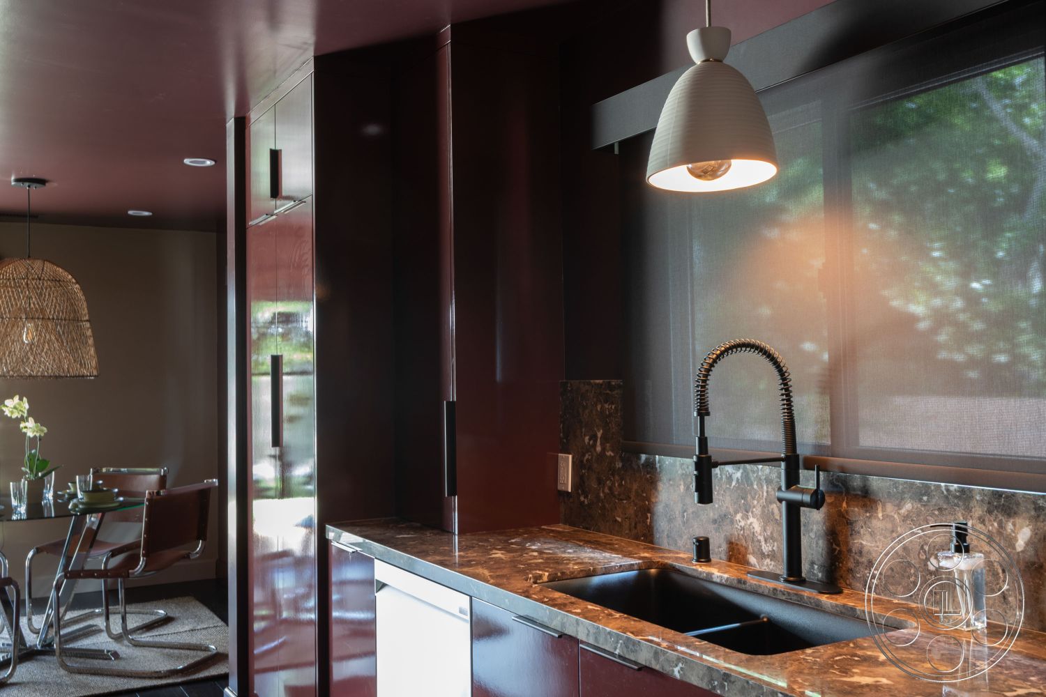 Bungalow 56 - dark wood cabinetry, recessed lighting, textured area rug, stainless steel appliances, black marble countertop, glass dining table, open concept living space, woven pendant light fixture, interior kitchen design, black granite backsplash, chrome dining chairs, smooth wall finish, natural light through large windows, modern urban apartment