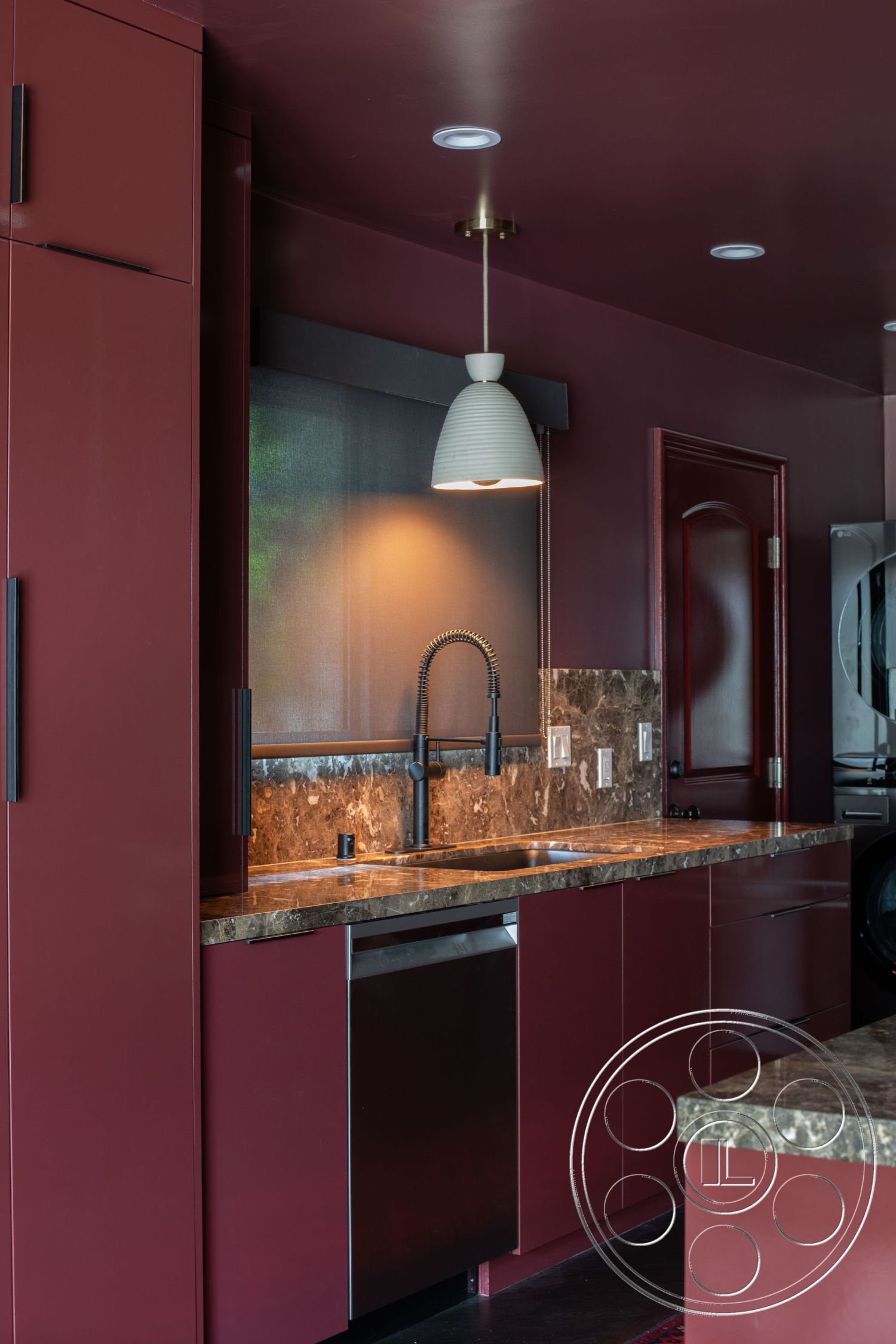 Bungalow 56 - modern pendant light fixture, recessed lighting fixtures, open kitchen layout, modern minimalist design, interior kitchen with burgundy cabinets, marble countertop with textured finish, stainless steel dishwasher, undermount sink with black faucet, laminate wood floor, dark cabinet hardware, glass window above sink, high-contrast color scheme, polished stone backsplash