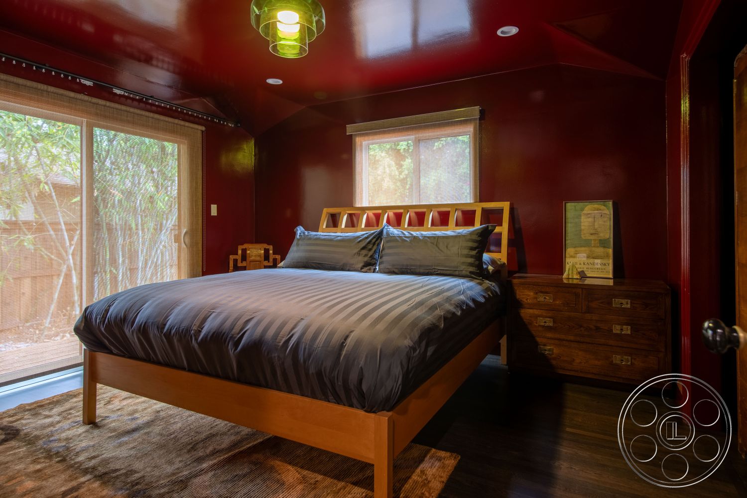 Bungalow 56 - exposed wood beam ceiling interior, red painted accent wall interior, hardwood bedroom floors interior, glass sliding doors interior, natural light windows interior, minimalist bedroom design interior, wooden bed frame interior, striped bedding interior, contemporary furniture interior, area rug texture interior, bamboo view setting interior, modern decor details interior