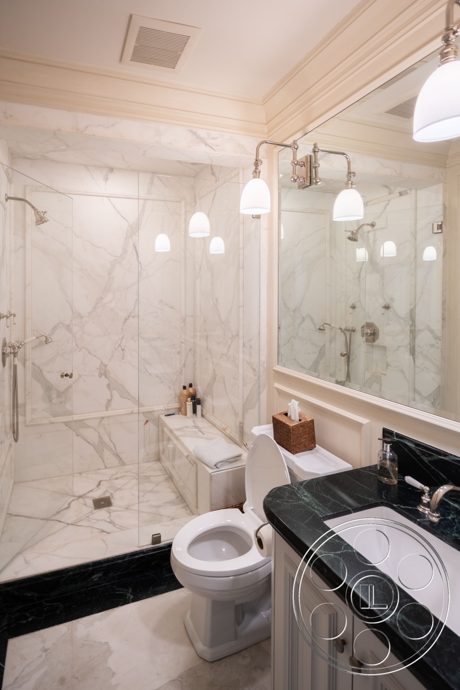 The Regent - interior pendant lighting fixtures, interior marble bathroom walls, interior marble shower enclosure, interior black marble flooring, interior white wood cabinetry, interior chrome faucet fixtures, interior glass shower doors, interior built-in bathtub, interior polished marble countertops, interior mirrored wall accents, interior textured ceiling with crown molding