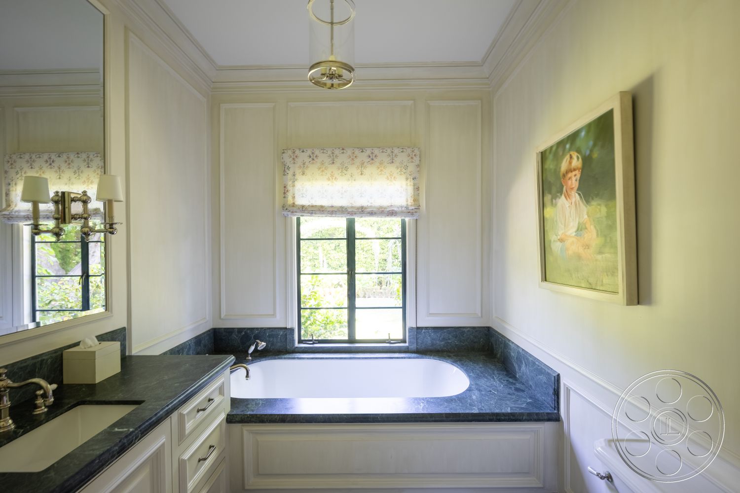 The Regent - double sink vanity, marble countertop, traditional wall sconces, dark stone backsplash, interior bathroom, white painted walls, bathtub with curved edge, framed artwork on wall, mirror above sink, wood window trim, fabric window treatment, classic molding details, subtle decorative accents