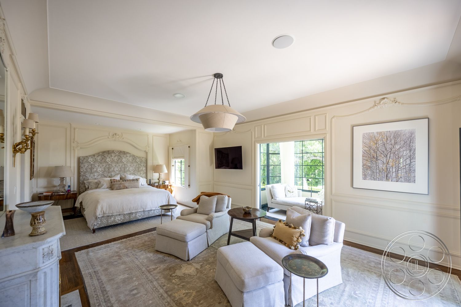 The Regent - neutral color palette, vaulted ceiling, soft area rug, elegant light fixtures, textured plaster walls, modern chandelier, upholstered headboard, luxurious bedding, decorative wall molding, natural light-filled space, hardwood bedroom floors, marble fireplace surround, coffered ceiling details, glass panel doors, large pane windows, small accent tables, exquisite wall art, interior master bedroom, stylish reading nook
