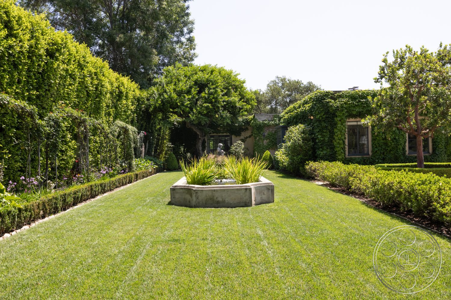 The Regent - outdoor seating area, stone pathway, tropical foliage, shade trees, ornamental grasses, urban garden retreat, perennial flower beds, exterior garden, boxwood hedge borders, concrete garden planter, lush greenery landscape, manicured grass lawn, vines on walls, wooden trellis support, architectural planting beds, sun-drenched garden setting, functional outdoor sculptures, modern landscaping design, flowering plants in garden, privacy wall with vegetation
