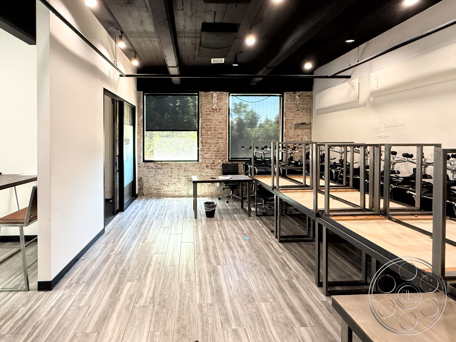 Office 124 - wood beam ceiling interior, exposed brick accent wall interior, functional workspace interior, laminate wood plank flooring interior, linear pendant lighting interior, metal frame furniture interior, glass window treatments interior, open layout workspace interior, minimalist desk design interior, industrial-style decor interior, modern office space interior, natural light from windows interior, contemporary furnishings interior, residential atmosphere interior