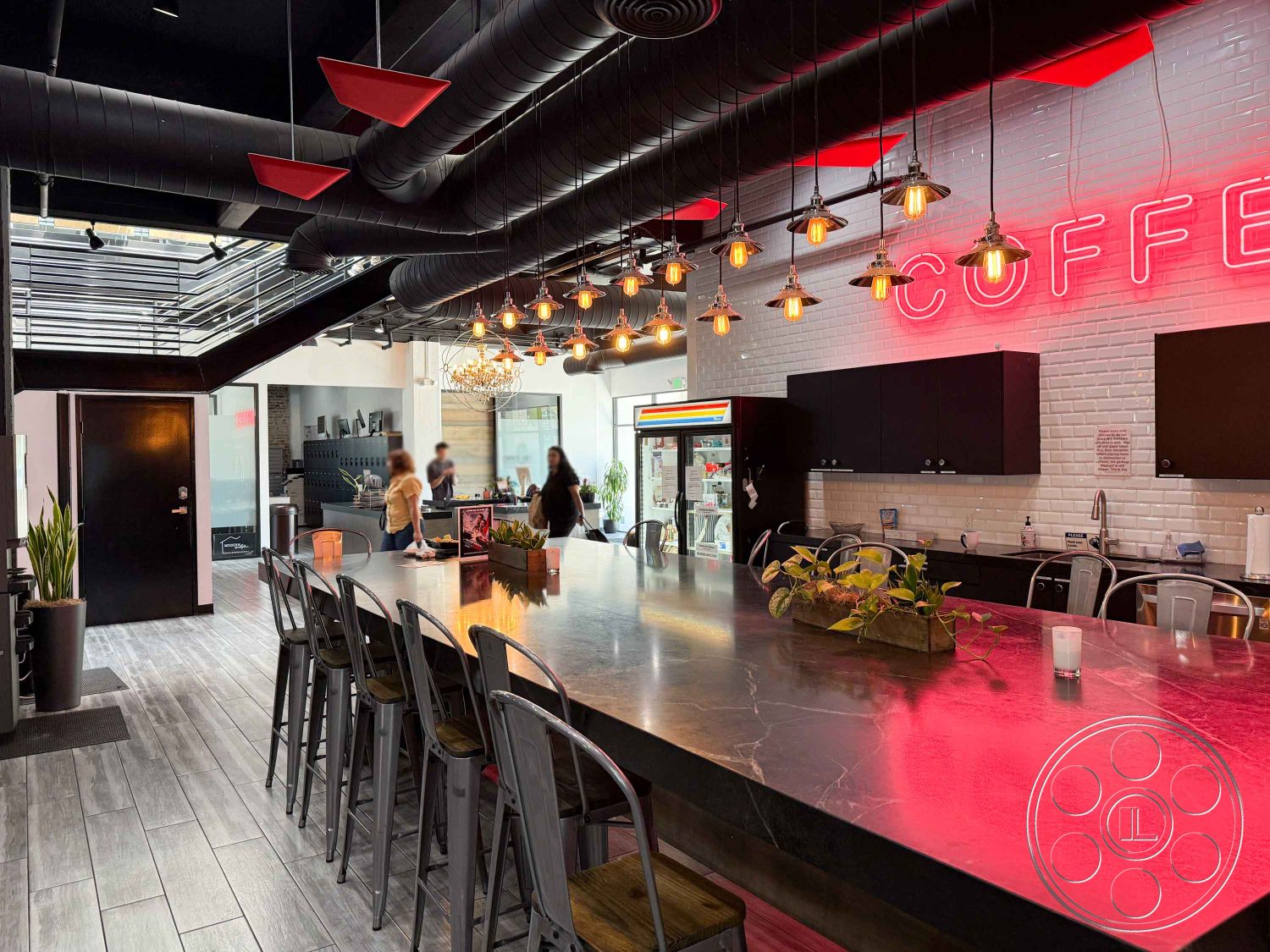 Office 124 - minimalist design, wooden bar stools, modern lighting fixtures, large glass windows, green indoor plants, black cabinetry, linear pendant lighting, bar area, open-concept layout, white subway tile backsplash, industrial-style décor, exposed ductwork ceiling, interior coffee shop, metal countertop, neon coffee sign, hardwood-style tile flooring