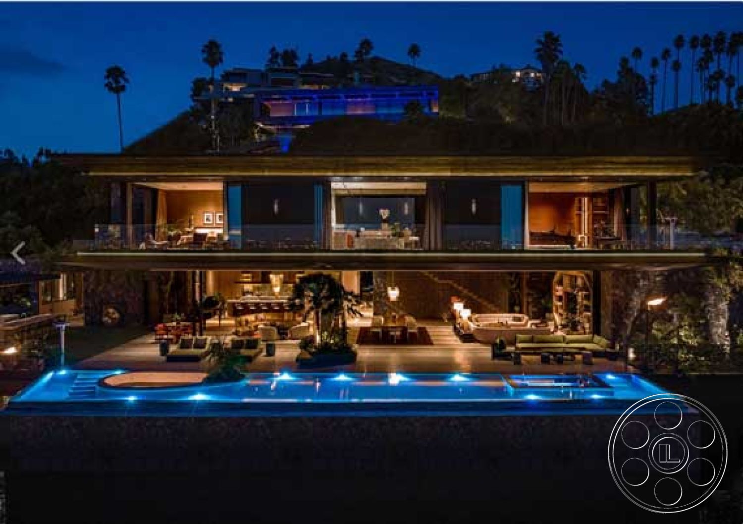 Modern 507 - exterior: infinity pool with LED lighting, exterior: concrete pool deck, interior: floor-to-ceiling windows with panoramic views, interior: dark wood paneling in living area, interior: open-concept living space, interior: recessed lighting fixtures, exterior: multi-level terrace with glass railings, interior: modern furniture arrangement in living room, interior: circular dining table, exterior: landscaped garden with palm trees, exterior: hillside location with surrounding greenery, interior: plush sectional sofa around living area, interior: contemporary kitchen with stainless steel appliances, exterior: wraparound patio with lounge chairs, interior: luxury finishes with marble countertops, exterior: glass doors opening to outdoor space, interior: ambient lighting for evening atmosphere