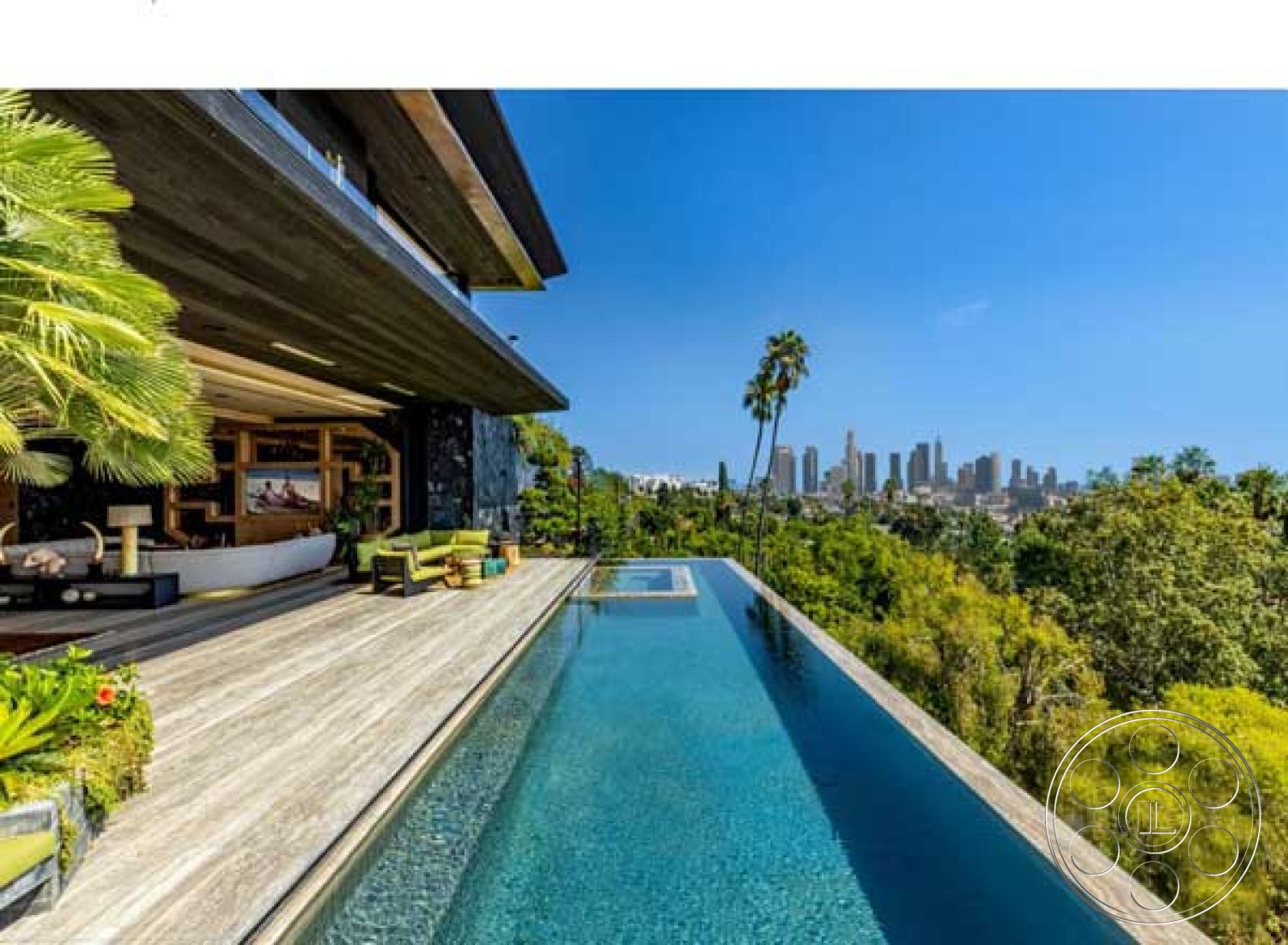 Modern 507 - interior: open-concept living area with floor-to-ceiling windows, exterior: infinity pool with stone edge, exterior: wooden deck flooring with natural finish, interior: modern sectional sofa with decorative cushions, exterior: tropical landscaping with palm trees, exterior: panoramic city skyline view, interior: contemporary decorative art pieces, interior: large glass sliding doors opening to outdoor area, exterior: sleek modern architecture with horizontal wood siding, exterior: built-in seating area adjacent to the pool