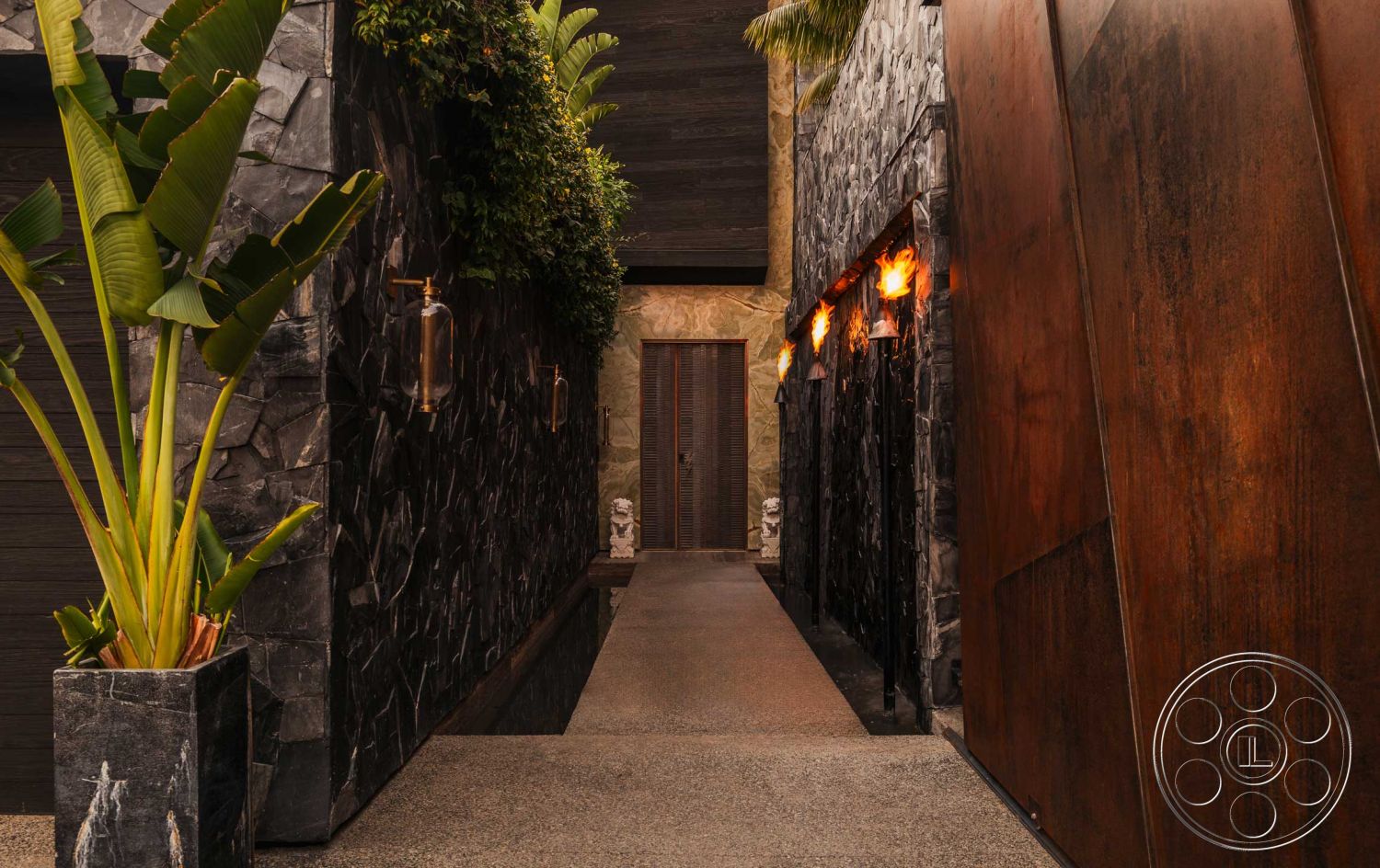 Modern 507 - polished concrete flooring, urban setting, concrete walkway, exposed stone wall, decorative stone planters, textured plaster wall, modern architectural design, rusted metal panel accent wall, hardscape pathway, landscaped tropical greenery, wall-mounted lanterns, narrow entrance corridor
