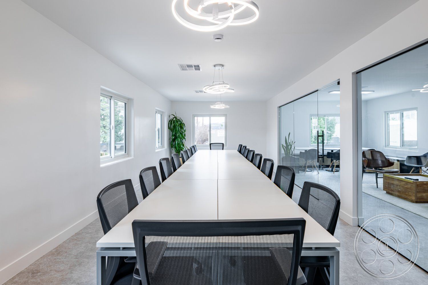 Office 125 - minimalist decor, neutral color palette, contemporary pendant lighting, floor-to-ceiling windows, textured carpet flooring, natural light emphasis, functional meeting space, rectangular conference table, interior conference room, open workspace layout, modern white painted walls, mesh office chairs, large glass partition walls, green indoor plant accent