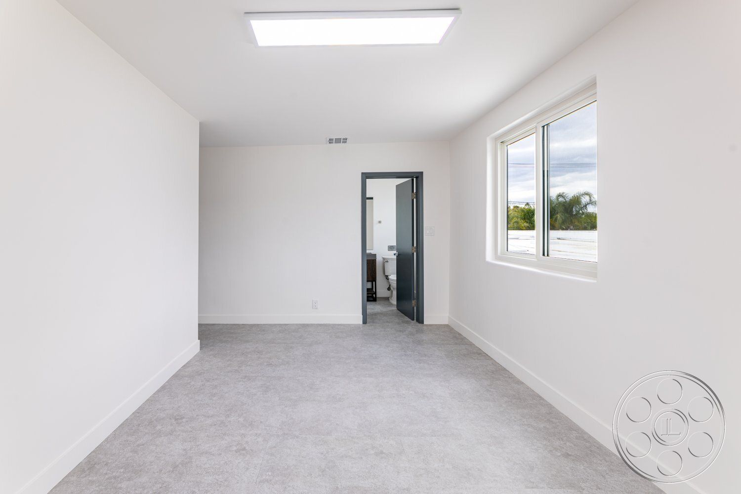 Office 125 - neutral color palette, minimalist design, open layout, modern interior, interior space, floor-to-ceiling windows, soft natural light, simple geometric shapes, white painted walls, contemporary ceiling lights, light gray tile flooring, non-textured wall finishes, sliding door entry to bathroom, functional room space, versatile room usage