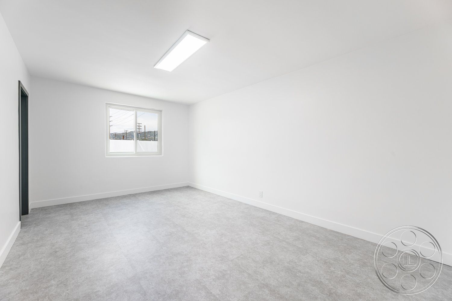 Office 125 - neutral color palette, minimalist design, open floor plan, flat ceiling, vinyl flooring, modern light fixture, smooth wall finish, white painted walls, ample natural light, grey vinyl floor tiles, single-hung window with mountain view, rectangular room shape, baseboard trim
