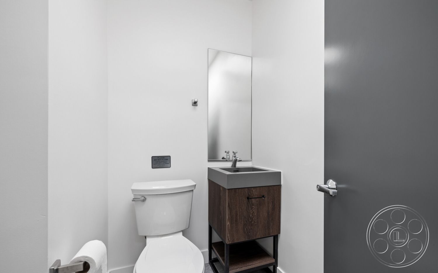Office 125 - bathroom, neutral color palette, white painted walls, interior bathroom, chrome faucet fixtures, modern door design, minimalist bathroom decor, mirror above sink, dark wood vanity cabinet, granite bathroom sink, toilet with soft-close lid, contemporary light fixture