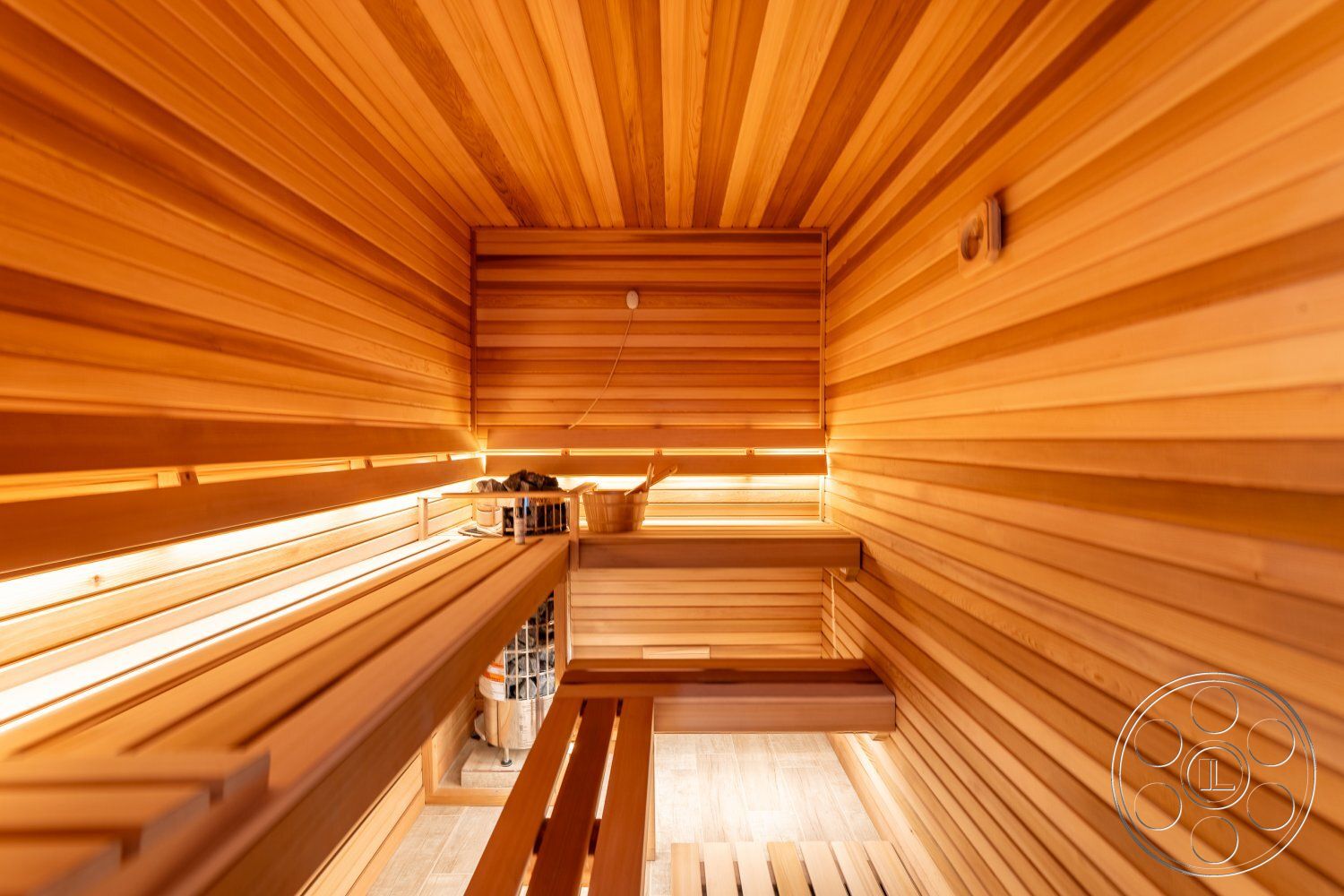 Office 125 - sauna, spa-like atmosphere, natural wood finishes, smooth wood flooring, interior sauna with cedar wall paneling, cedar bench seating, ambient lighting integrated in wood paneling, textured wooden ceiling, slatted wood bench construction, soft, warm-toned wood accents