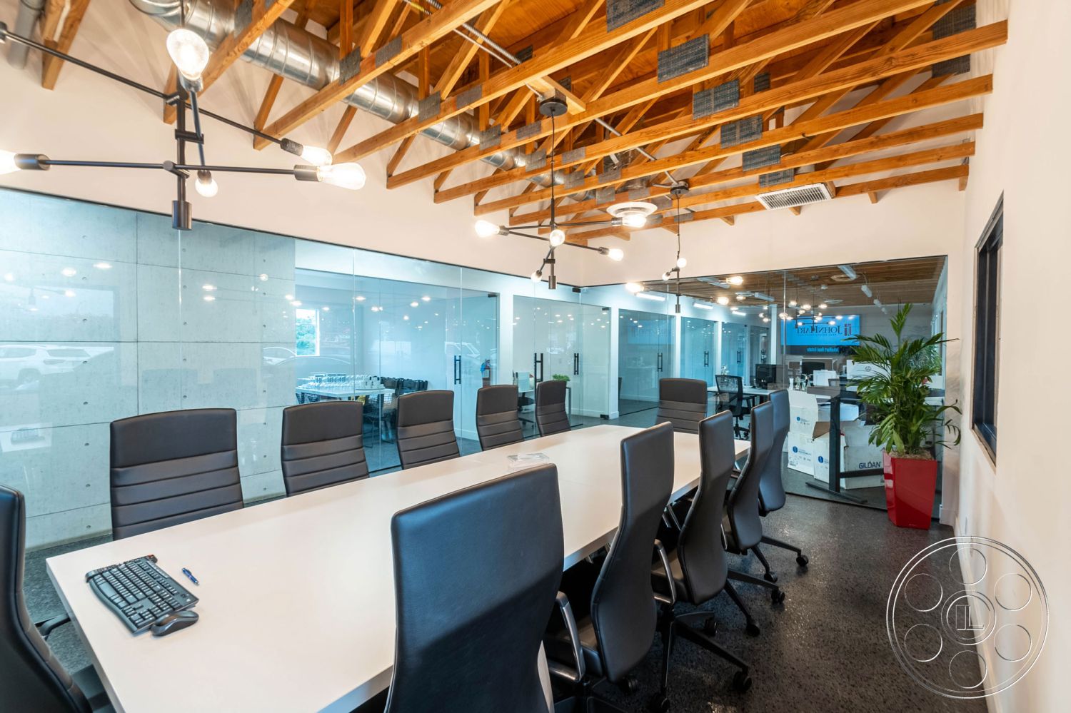 Office 126 - conference room, glass partition walls interior, floor-to-ceiling windows interior, wood beam ceiling interior, concrete walls interior, slate flooring interior, modern conference table interior, recessed lighting fixtures interior, exposed ductwork interior, black leather office chairs interior, minimalist desk setup interior, open office environment exterior, urban commercial building exterior, industrial-style architecture exterior, natural light through glass walls interior