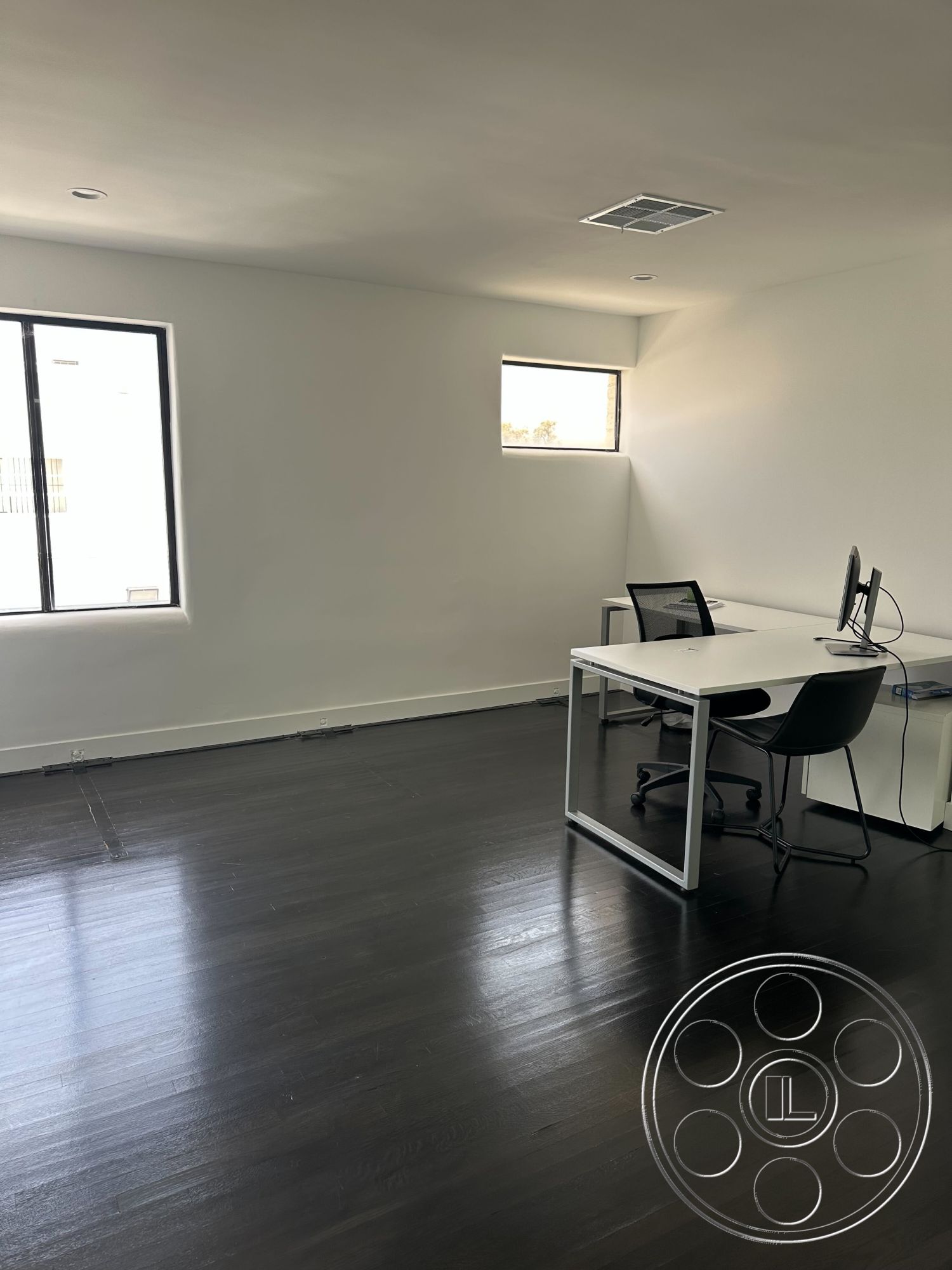 Office 127 - modern office chair, black hardwood flooring, natural light illumination, white painted walls, open layout design, interior office space, contemporary ceiling design, large windows with black frames, minimalist desk setup