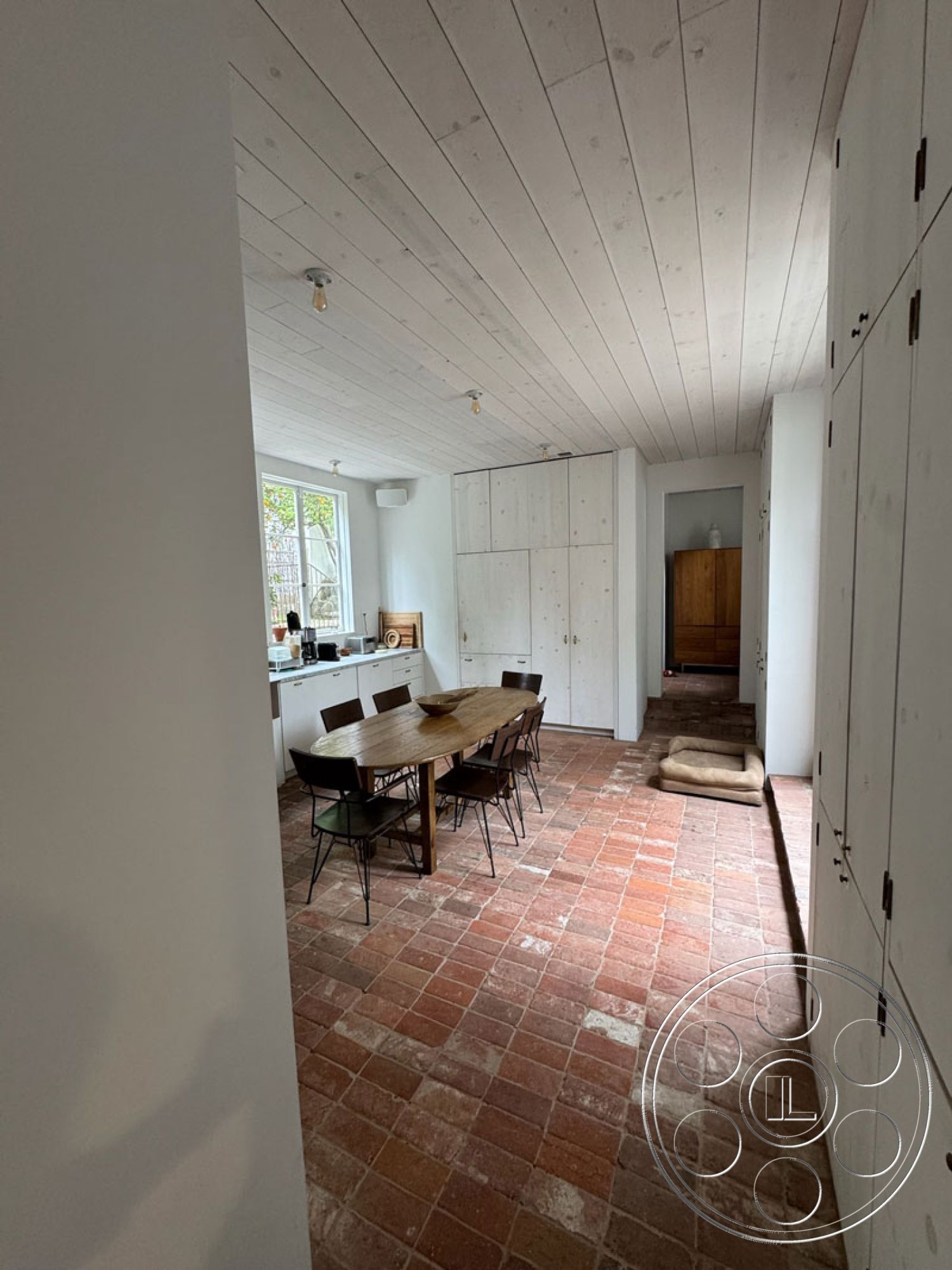 Spanish 165 - large windows for natural light, minimalist cabinetry, contemporary light fixtures, earth-toned decor, functional storage solutions, exposed wood beam ceiling, spacious room with natural light, interior brick tile flooring, white shiplap accent walls, modern dining area with wood table, rustic wood dining chairs, open plan kitchen layout, textured wood ceilings, inviting dining space