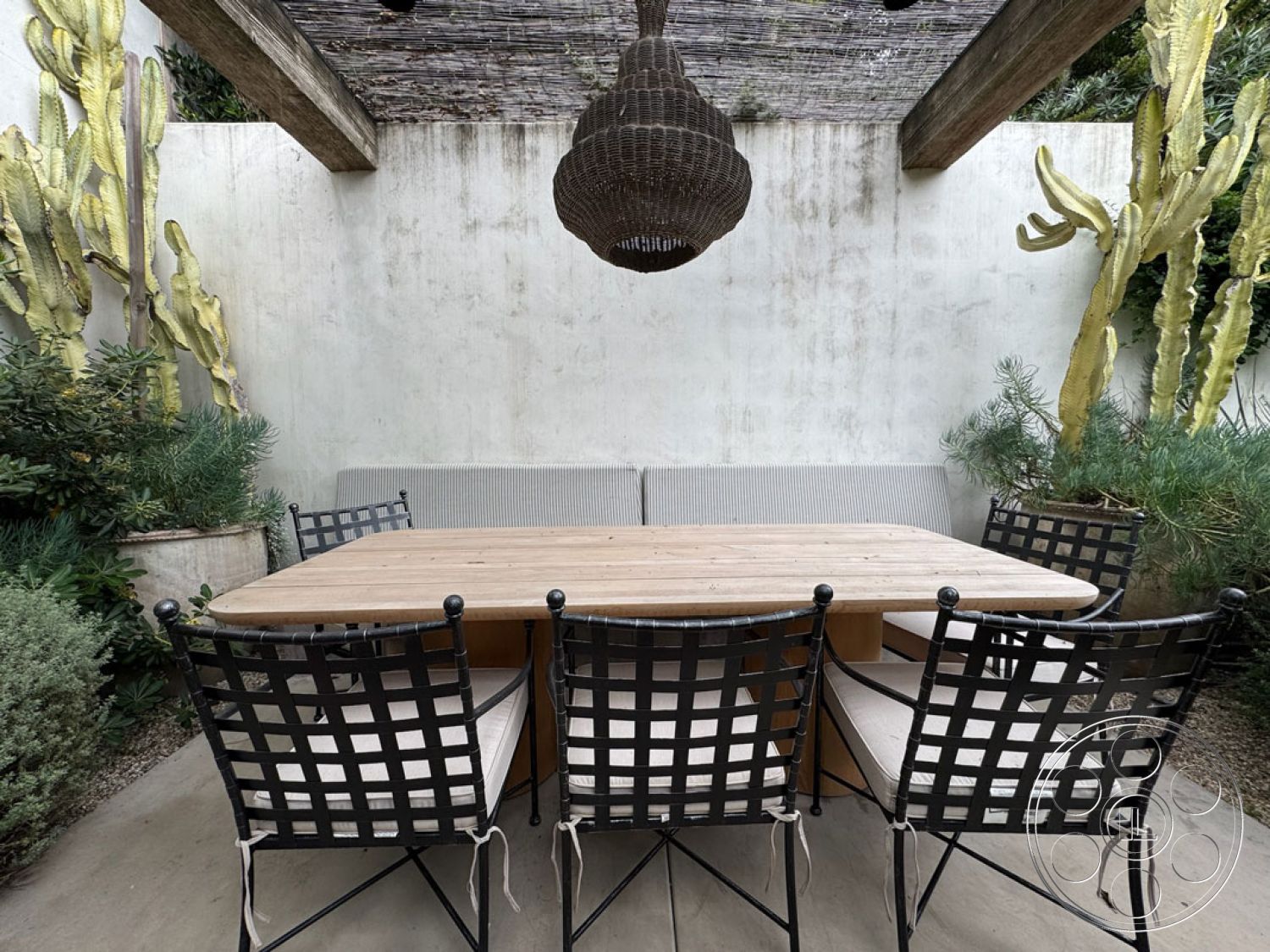 Spanish 165 - wood dining table, landscaped greenery, natural stone flooring, woven light fixture, textured plaster walls, succulent garden, metal outdoor chairs, wood beam ceiling, exterior patio area, minimalist outdoor design, stone garden planters, rustic outdoor seating, modern desert setting