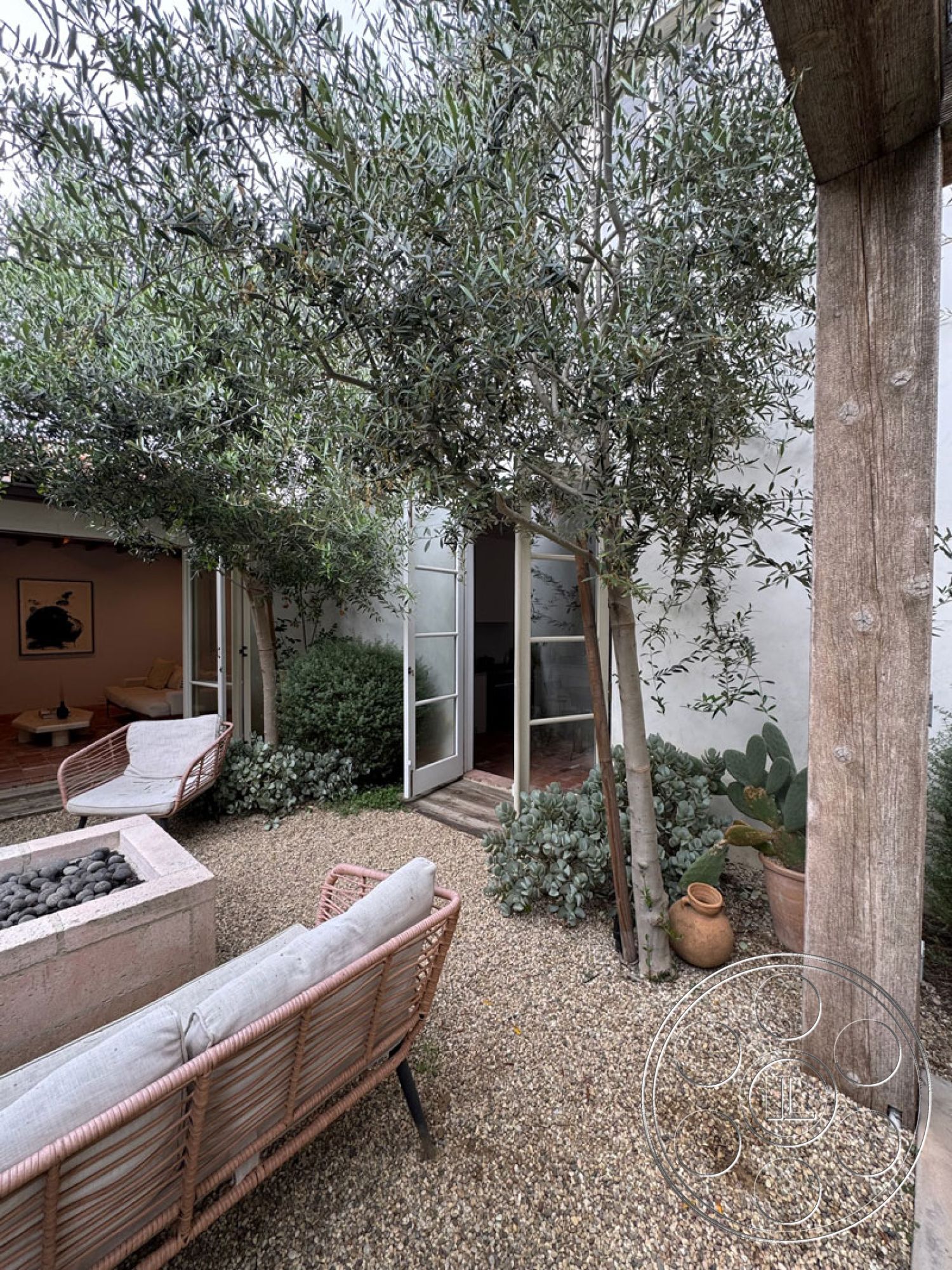 Spanish 165 - modern outdoor furniture, exposed wood ceiling beams, gravel patio flooring, minimalist landscape design, exterior courtyard landscaping, potted plant arrangements, olive trees surrounding, poured concrete garden planter, glass door transitions, natural stone garden accents, soft landscape borders, artistic outdoor seating area, neutral color palette furniture, domestic outdoor living space, suburban garden retreat