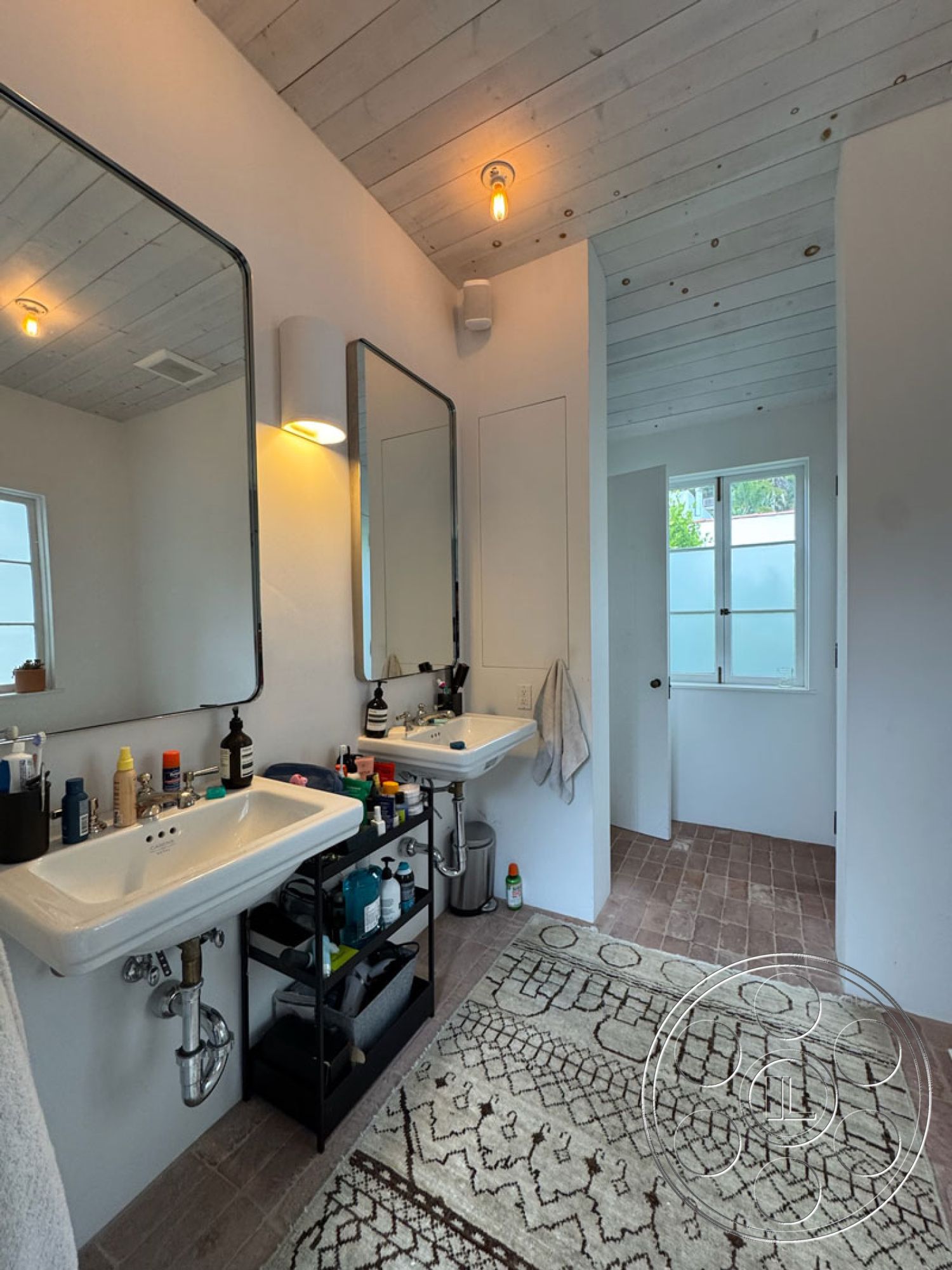 Spanish 165 - minimalist decor, neutral color palette, spacious layout, double sink vanity, natural light from windows, rectangular mirrors, modern bathroom fixtures, interior bathroom, functional storage solutions, white painted walls, wood plank ceiling, black metal bathroom shelving, porcelain tile flooring, beige textured area rug, brushed nickel faucets, bright illumination