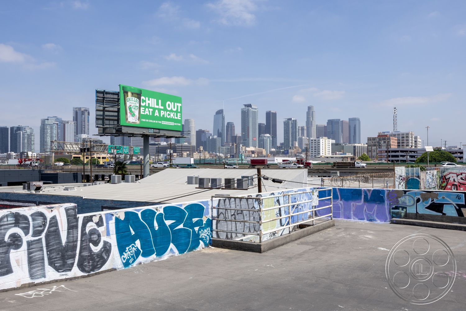 Rooftop 51 - graffiti wall art, mixed-use buildings, flat roof design, metal railing details, urban skyline backdrop, cityscape panorama, surrounding urban landscape, exterior rooftop view, concrete rooftop surface, billboard signage, industrial urban setting, asphalt rooftops, high-rise structures, street-level visibility, vibrant street culture