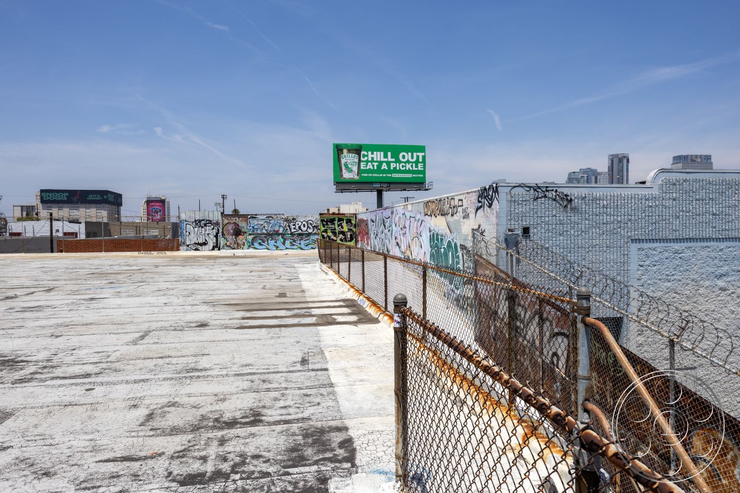 Rooftop 51 - urban landscape, city skyline view, graffiti-covered walls, industrial urban environment, concrete rooftop surface, billboard signage, exterior urban rooftop, chain link fence with rust, weathered asphalt texture, metal fence details, dilapidated building facades