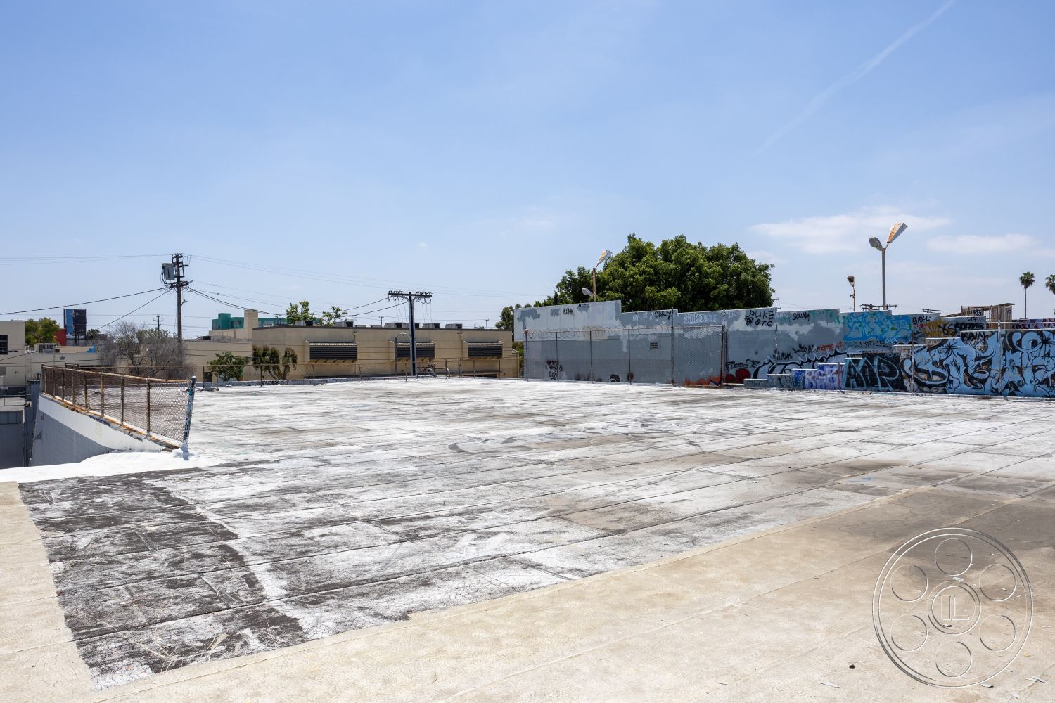 Rooftop 51 - metal railing, urban setting, graffiti wall art, sunlit exterior, flat roof design, exposed electrical wiring, industrial urban landscape, concrete rooftop surface, minimalist rooftop, surrounding city view, public art installation