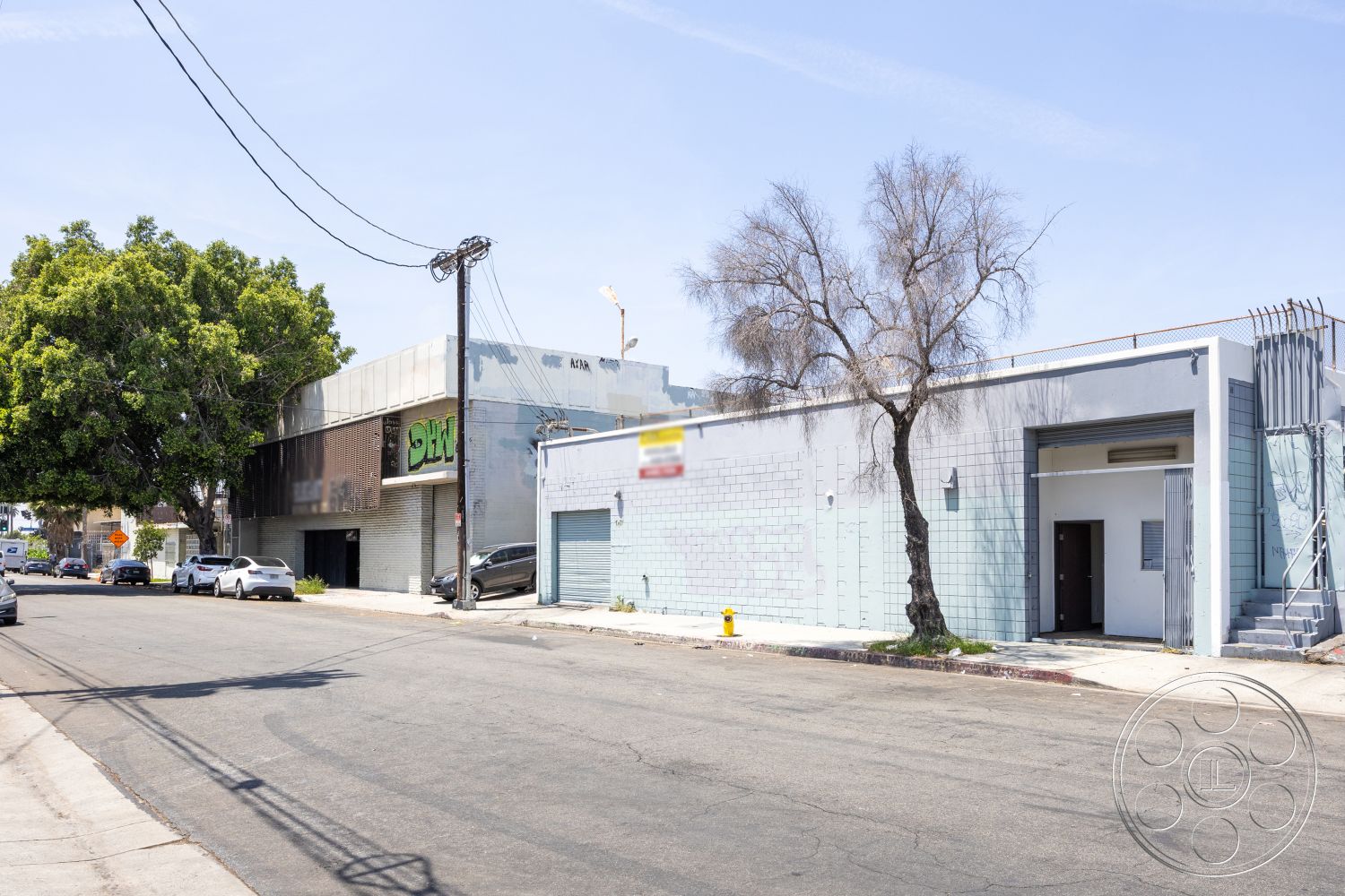 Warehouse 61 - urban setting, modern exterior, tree landscaping, open parking area, concrete sidewalk, flat roof design, exterior concrete walls, industrial-style architecture, glass entrance door, grey tile facade, metal sliding door, exposed steel framing, street-level commercial space, wired for utilities, side stair access, decorative metal railing, high visibility storefront