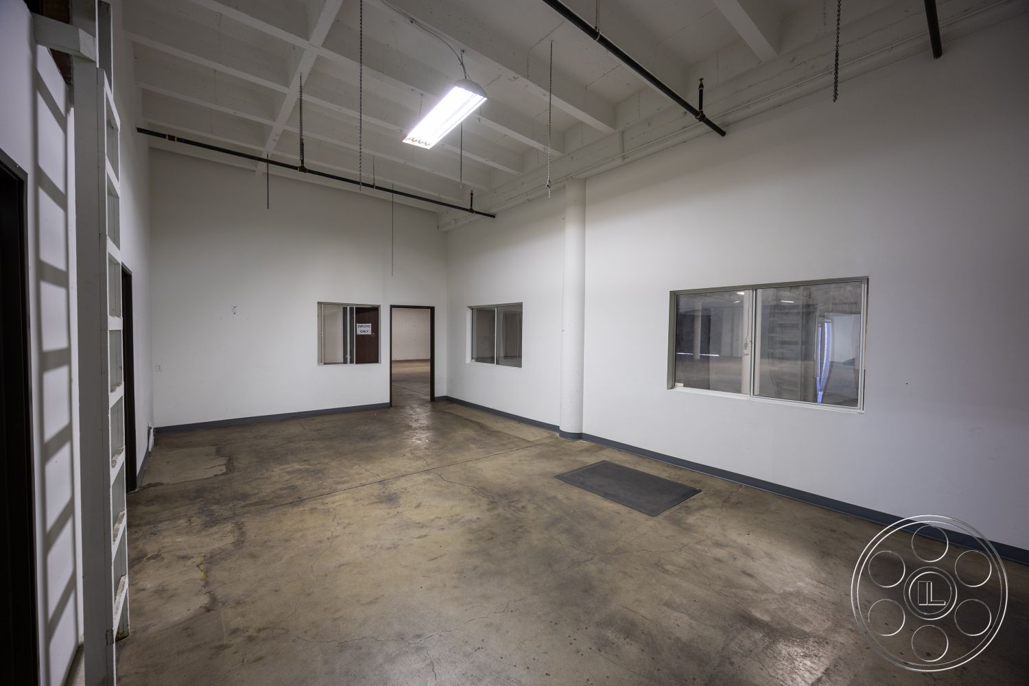 Warehouse 61 - high ceilings, neutral color palette, large glass windows, textured concrete walls, flexible layout, functional workspace, commercial space, exposed concrete floor, minimalist interior, drywall interior walls, industrial ceiling design, flat ceiling with beams, open floor plan space