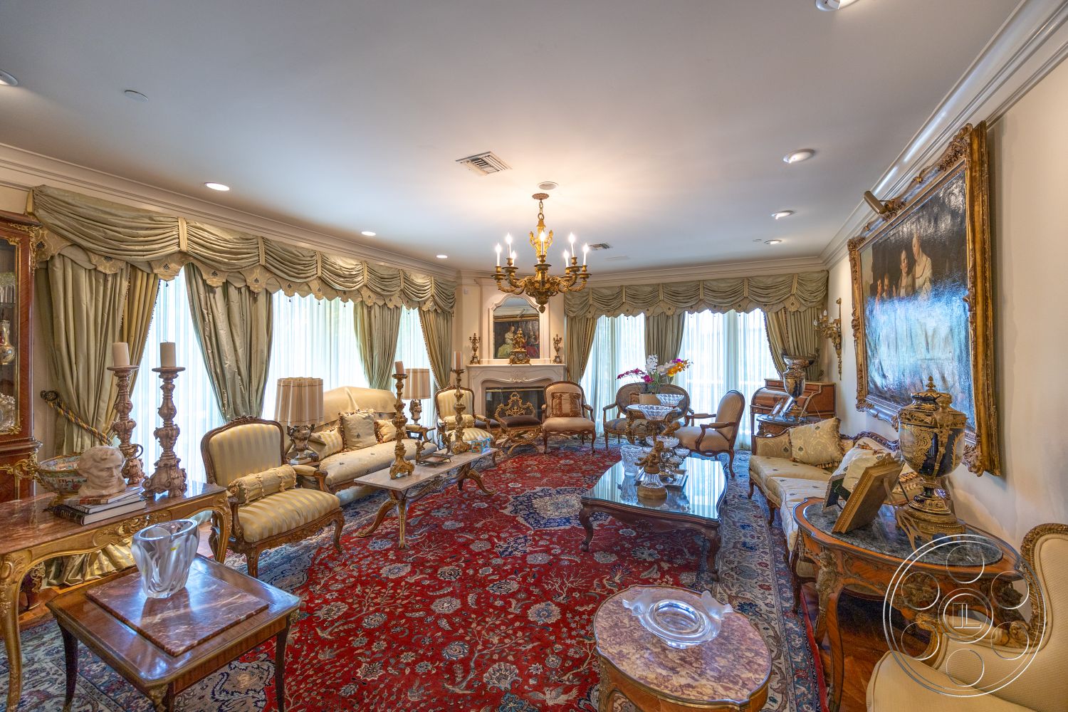 Medit 165 - hardwood flooring, coffered ceiling, glass coffee table, decorative pottery, luxurious living room, plush area rug, upholstered seating, exposed crown molding details, gold-accented furniture, Ornate chandelier, silk drapery, decorative wood side tables, vintage art pieces, intricate fireplace mantel, wall-mounted paintings, heavy velvet curtains, ornate floor lamp, tassel-trimmed throw pillows, vintage decorative vases