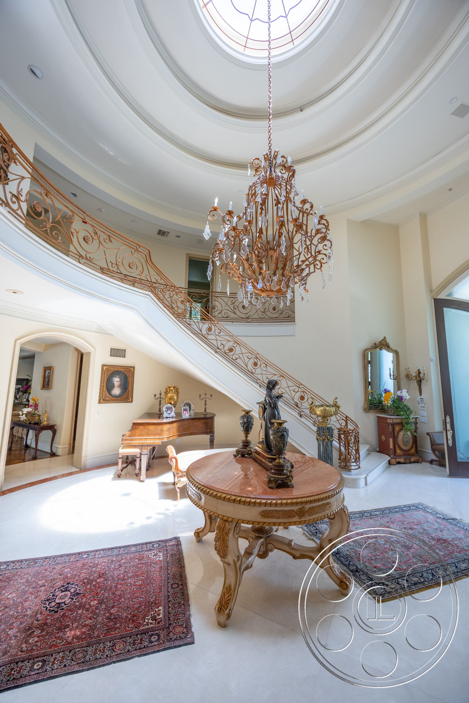Medit 165 - traditional area rugs, intricate ceiling design, white painted walls, spacious open layout, exposed wood ceiling details, interior chandelier lighting, curved wooden staircase, marble entryway flooring, ornate metal railing, rounded ceiling with skylight, decorative wall moldings, classic wooden piano, elegant decorative sculptures, glazed wooden doors, antique-style furniture, high ceilings with accent lighting, gold trim details, antique mirror accents, formal entryway design, luxurious foyer setting