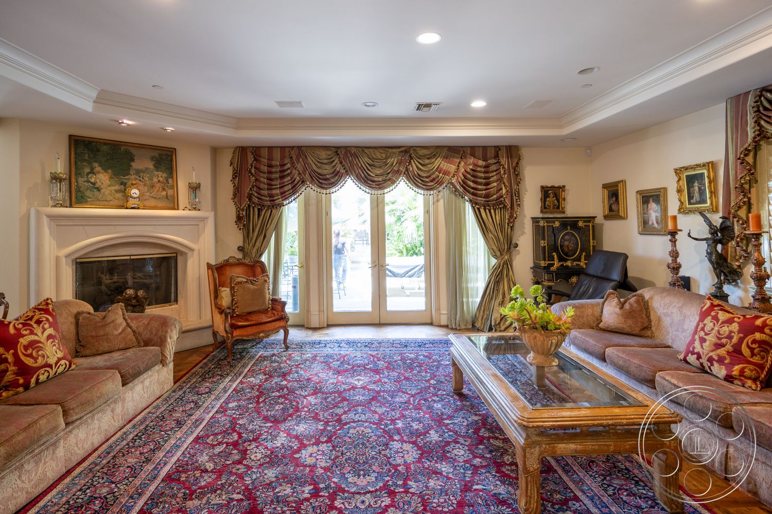 Medit 165 - exposed beam ceiling, comfortable seating area, traditional armchair, glass top coffee table, interior living room, hardwood floor living room, oriental area rug, stone fireplace surround, crown molding details, antique wooden furniture, traditional upholstered sofa, glazed double doors, decorative window drapes, ornate wall art, floral pattern throw pillows