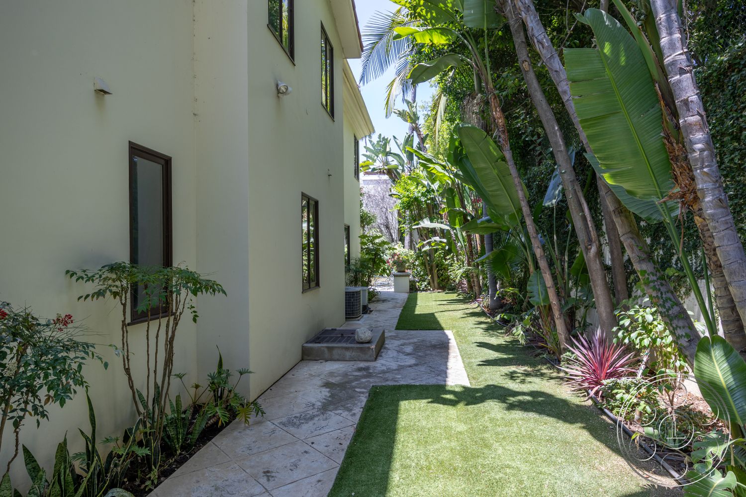 Medit 165 - exterior, modern architecture, lush greenery, concrete pathway, light-colored stucco walls, tall palm trees, outdoor aesthetic, landscaped garden area, tropical plant landscaping, urban tropical setting, rectangular window shapes, stepped pathway design, artificial grass lawn, shrubbery border, exterior wall-mounted lighting fixtures, garden planter boxes, narrow garden passage, open-air ambiance