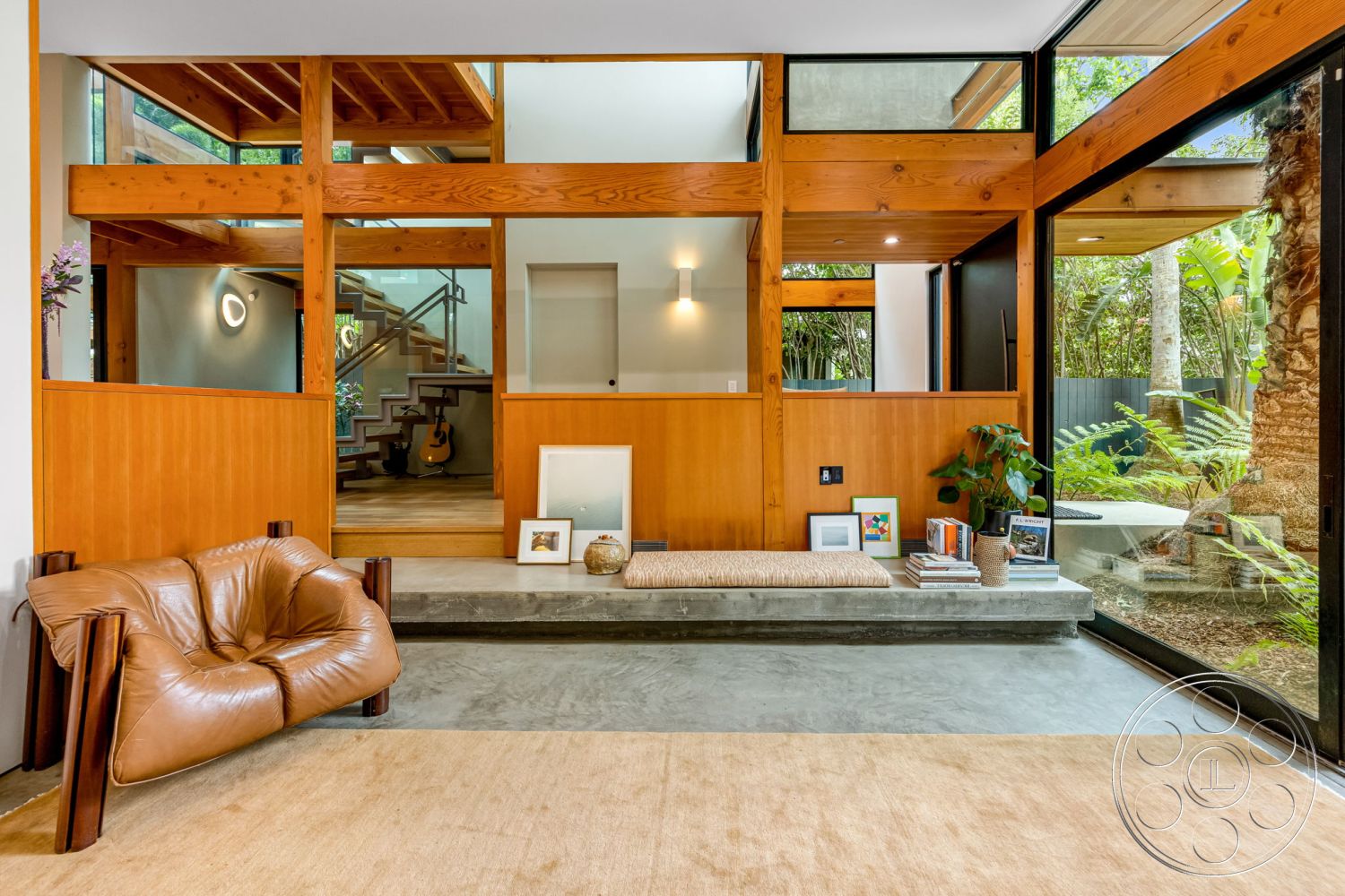 Modern 508 - exposed wood ceiling beams interior, indoor plant decor interior, natural light from large windows interior, wood panel accent wall interior, open concept living space interior, concrete floor interior, glass wall partition interior, floating stairs interior, rectangular ottoman interior, hardwood staircase interior, modern leather armchair interior, multifunctional shelf space interior, minimalist design elements interior, warm wood tones interior, contemporary architectural style interior, integrated seating area interior, nature view setting interior