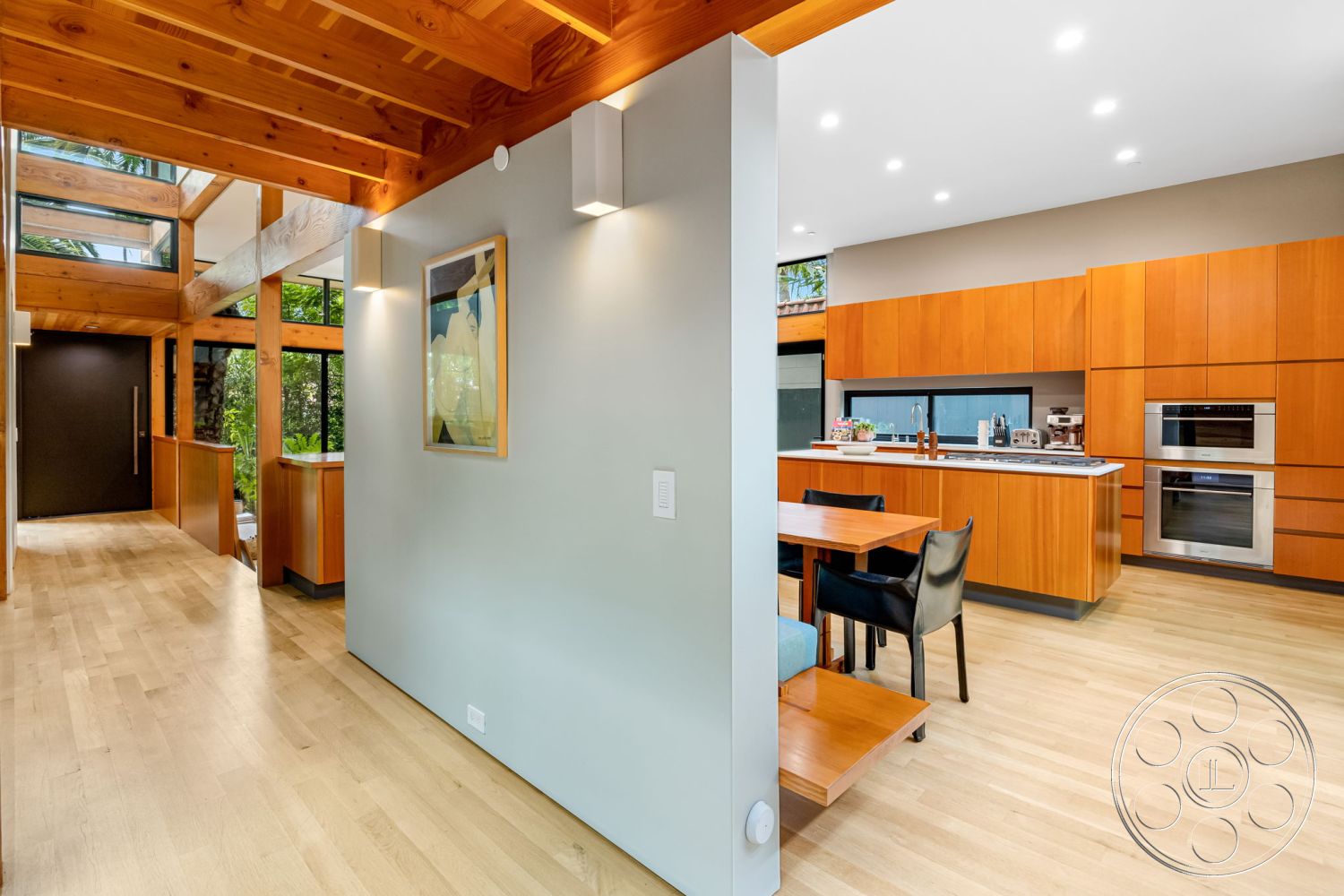 Modern 508 - light hardwood flooring, urban setting, floor-to-ceiling windows, open-concept living space, exposed wood ceiling beams, minimalist kitchen design, textured plaster wall treatment, built-in kitchen appliances, natural light ambiance, wood cabinetry in kitchen, modern interior lighting, glass wall elements, dark wood front door, contemporary art decoration, table for dining area, indoor plant integration
