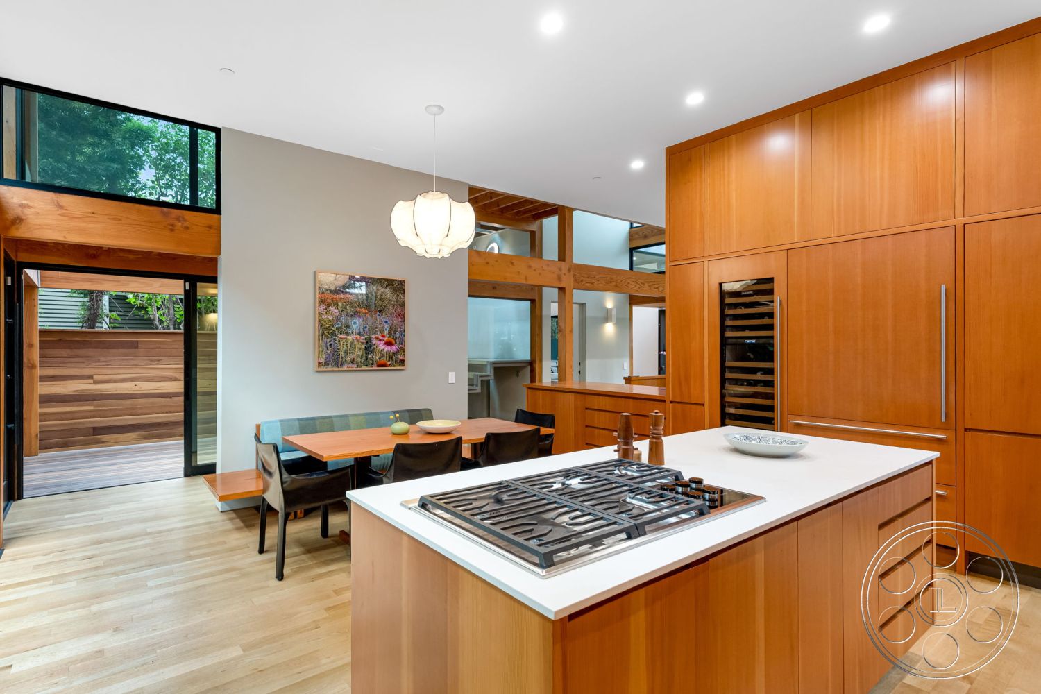 Modern 508 - neutral color palette, natural wood cabinetry, modern pendant lighting, sliding glass doors, interior garden view, seamless indoor-outdoor flow, rectangular dining table, modern kitchen design, contemporary architectural style, exposed wood ceiling beams, painted drywall walls, hardwood kitchen floors, quartz kitchen countertops, glass window walls, minimalist interior, integrated wine cooler, open-concept living-dining area, fixed glass panels