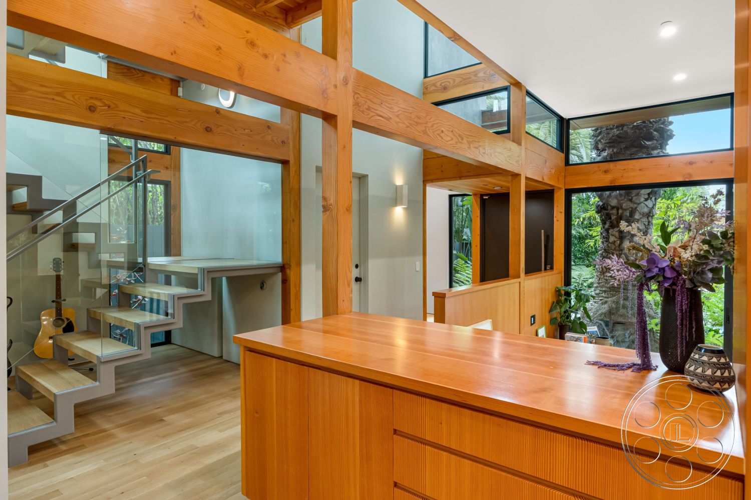 Modern 508 - textured wall panels, modern architectural style, large floor-to-ceiling windows, glass railing staircase, minimalist decor elements, interior open floor plan, exposed wooden ceiling beams, hardwood flooring in living area, vertical wood slat accent wall, contemporary kitchen island, floating wood staircase, light wood kitchen cabinetry, natural light filled spaces, outdoor greenery view, bright and airy interior