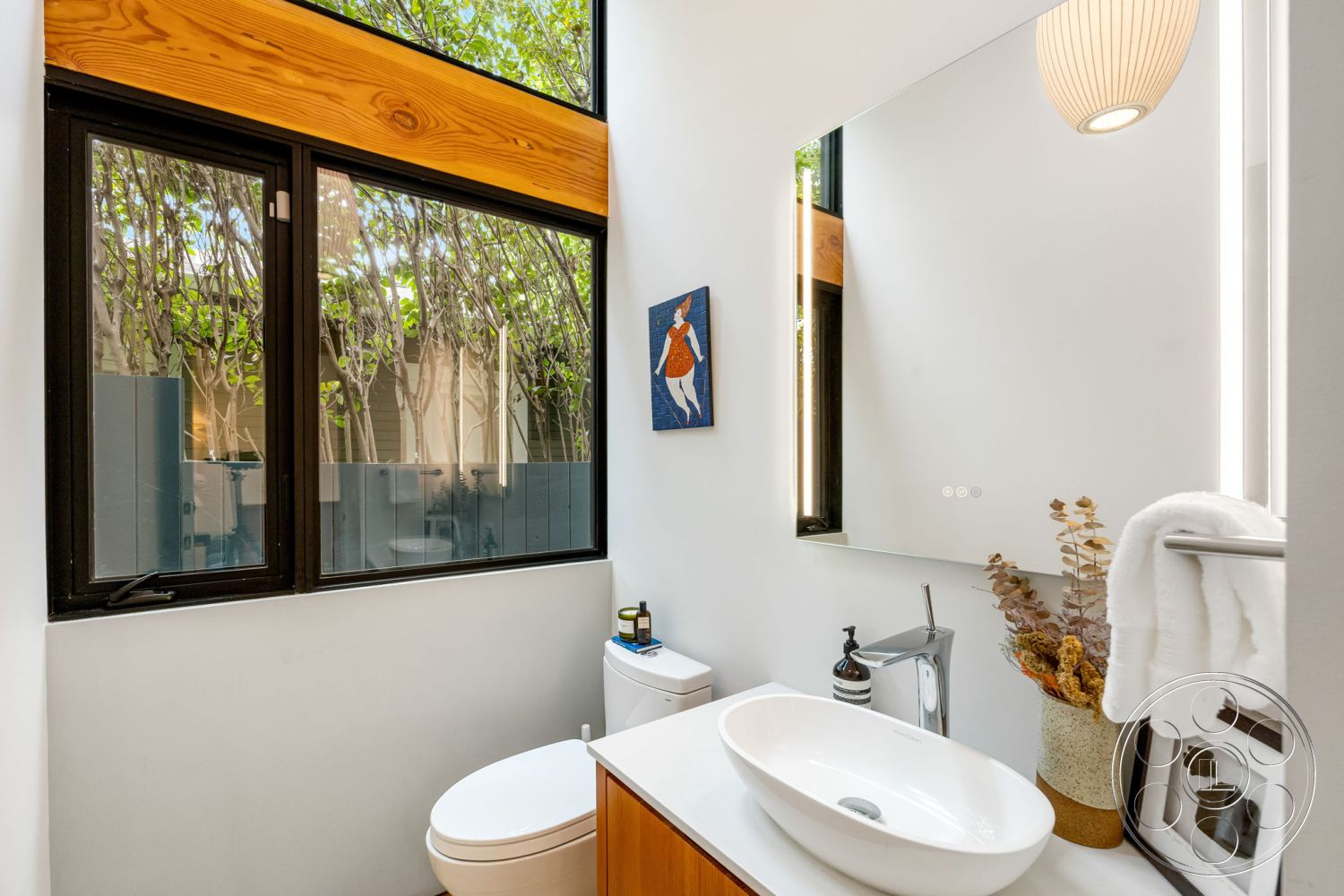 Modern 508 - neutral color palette, modern pendant lighting, decorative wall art, black window frames, textured wall finishes, natural light from windows, white porcelain toilet, interior bathroom design, minimalist bathroom decor, functional bathroom space, wood vanity with sink, ceramic bathroom sink, large frameless mirror, plant accents near windows, horizontal wood plank wall, luxurious toiletries, contemporary towel rack, open layout bathroom, stylish bathroom accessories, clean lines and shapes