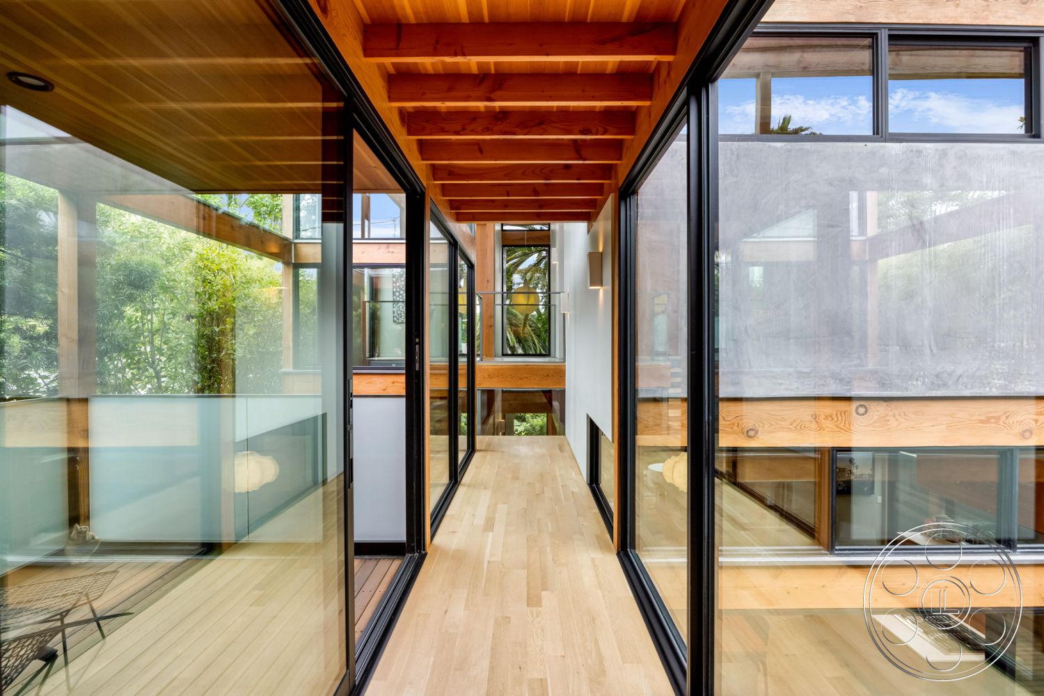 Modern 508 - large windows, exterior, contemporary design, natural wood flooring, indoor-outdoor flow, greenery view, sliding glass doors, textured concrete walls, bright natural lighting, modern architectural style, wood beam ceiling, glass wall panels, minimalist interior, open-air corridor, rustic wood accents