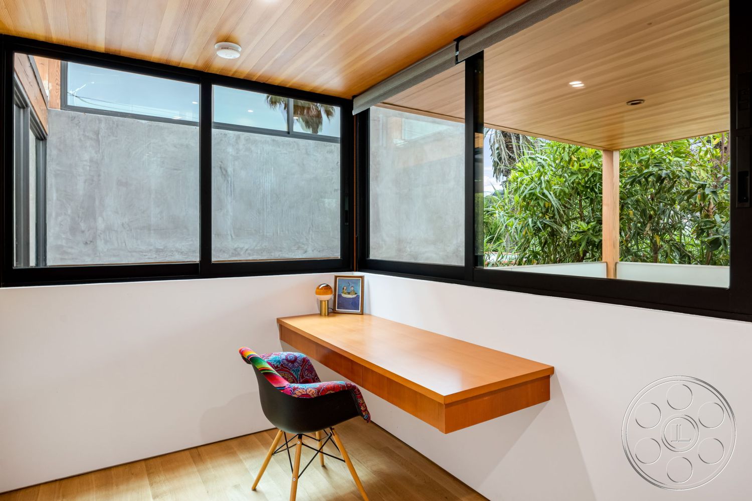 Modern 508 - neutral color palette, natural light, hardwood flooring, contemporary architectural style, white painted walls, concrete wall finish, modern office interior, open workspace design, exposed wood ceiling panels, minimalist desk design, large black-framed windows, surrounding greenery view, wall-mounted desk, corner workspace