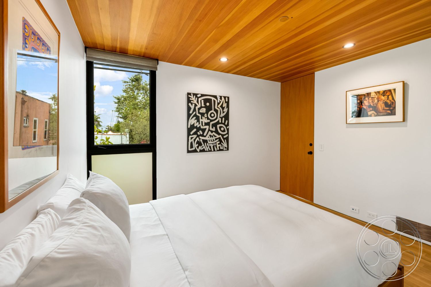 Modern 508 - minimalist design elements, floor-to-ceiling windows, contemporary architectural style, interior bedroom, white painted walls, natural light ambiance, framed artwork on walls, hardwood ceiling planks, king-size bed with white bedding, wood door with black handle