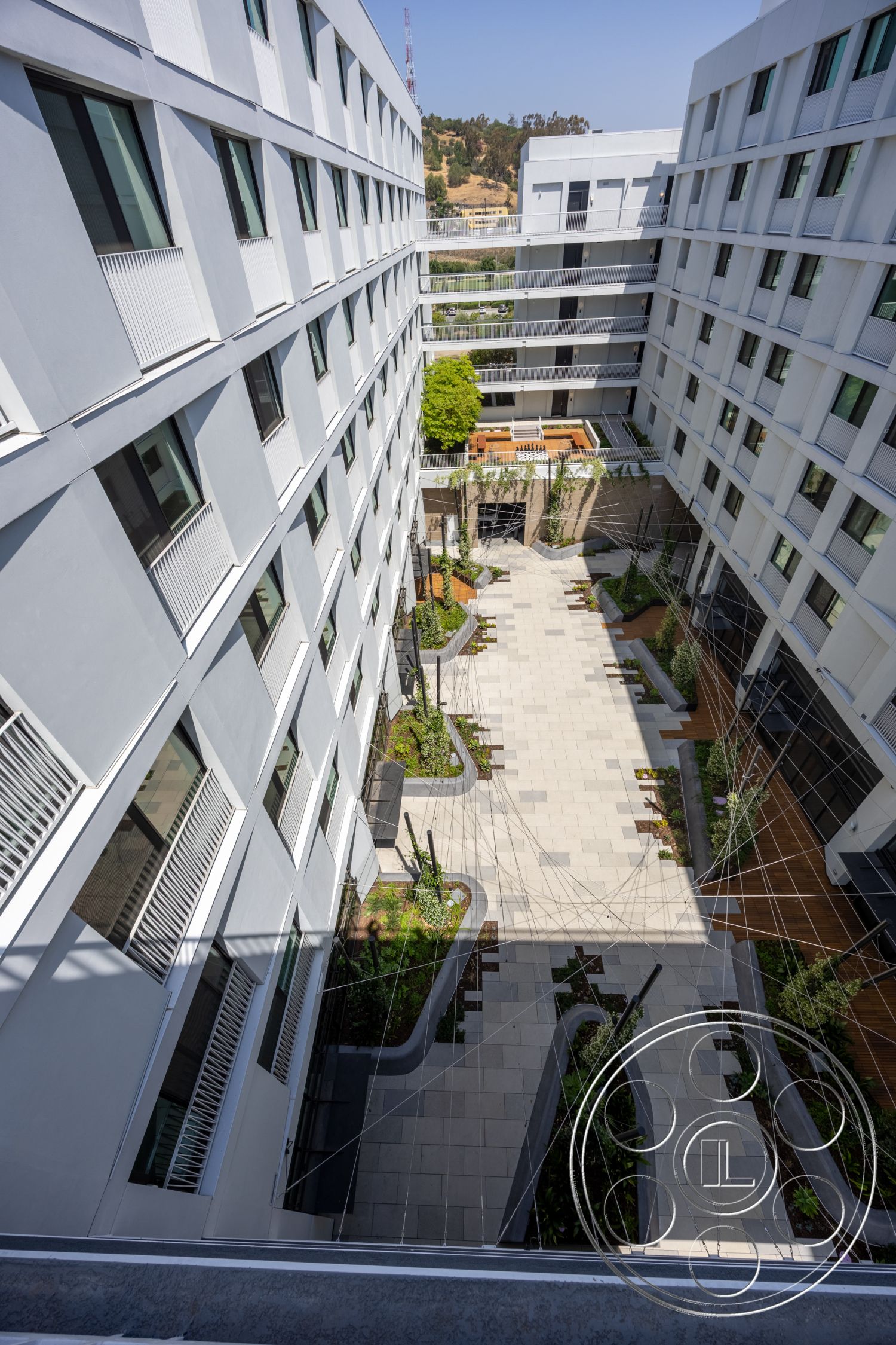 Apartment 55 - exterior modern architectural style, exterior glass balcony railings, interior garden patio, exterior concrete paver flooring, exterior wood planter boxes, exterior green landscaped areas, exterior sleek modern building design, exterior multi-story building facade, exterior linear garden pathways, exterior expansive windows, interior open courtyard space, interior landscaped areas with greenery, exterior contemporary design elements, exterior smooth stucco walls, exterior metal detailing, exterior patterned tile layout, exterior urban setting