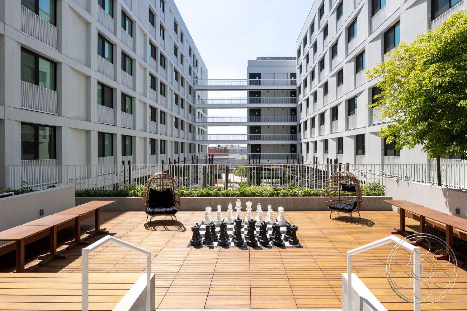 Apartment 55 - exterior, landscaped garden, modern architecture, outdoor seating area, metal railing, planter boxes, contemporary outdoor furniture, light-filled environment, sustainable design elements, flat roof design, wood deck flooring, rectangular patio space, concrete building walls, chessboard design, hanging chair seating, urban courtyard, city view background