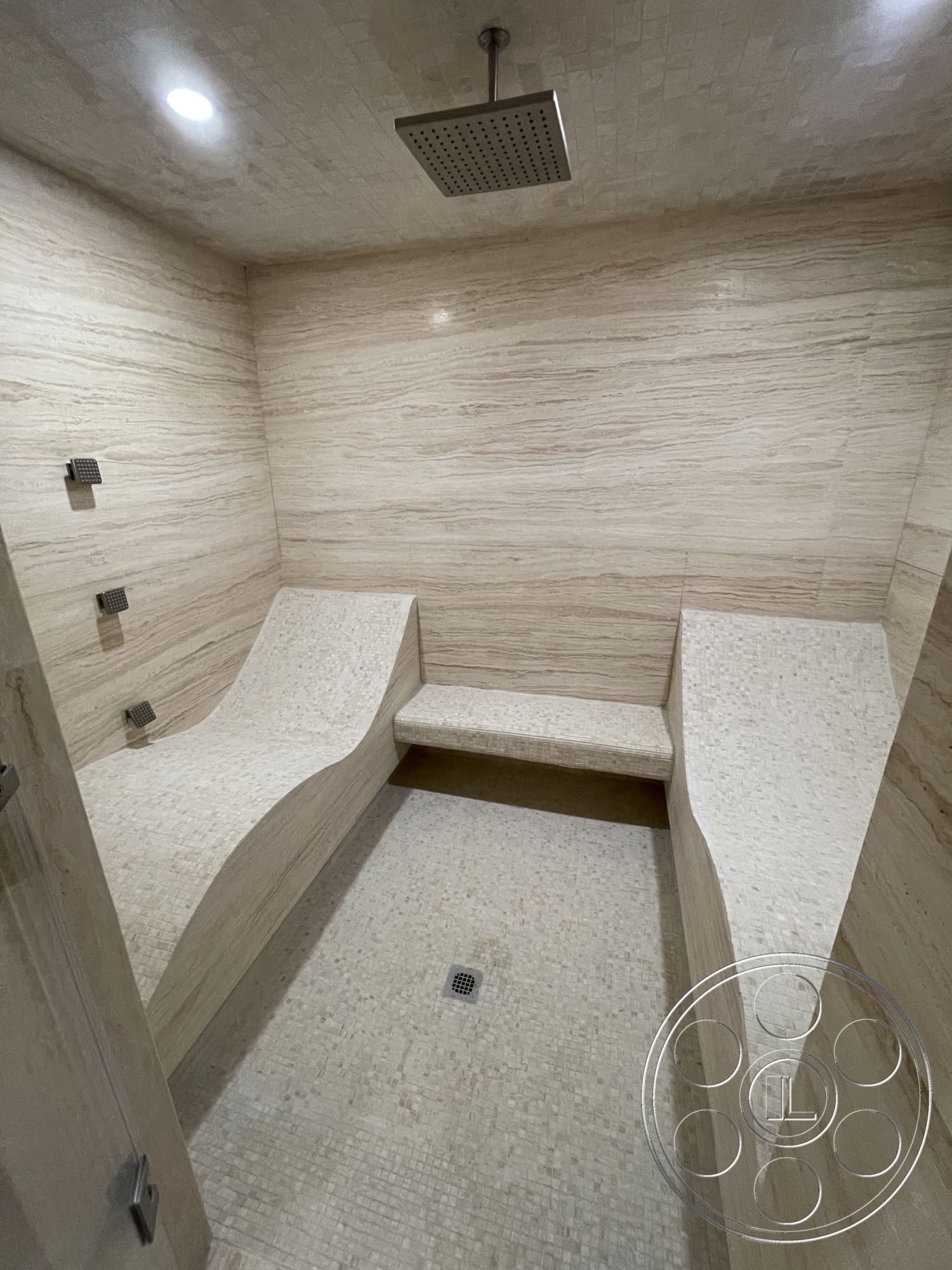Modern 509 - interior recessed lighting, interior warm neutral color palette, interior minimalist design, interior marble shower walls, interior mosaic stone shower floor, interior curved stone seating, interior rainfall showerhead, interior built-in shower benches, interior smooth stone texture, interior luxury spa atmosphere