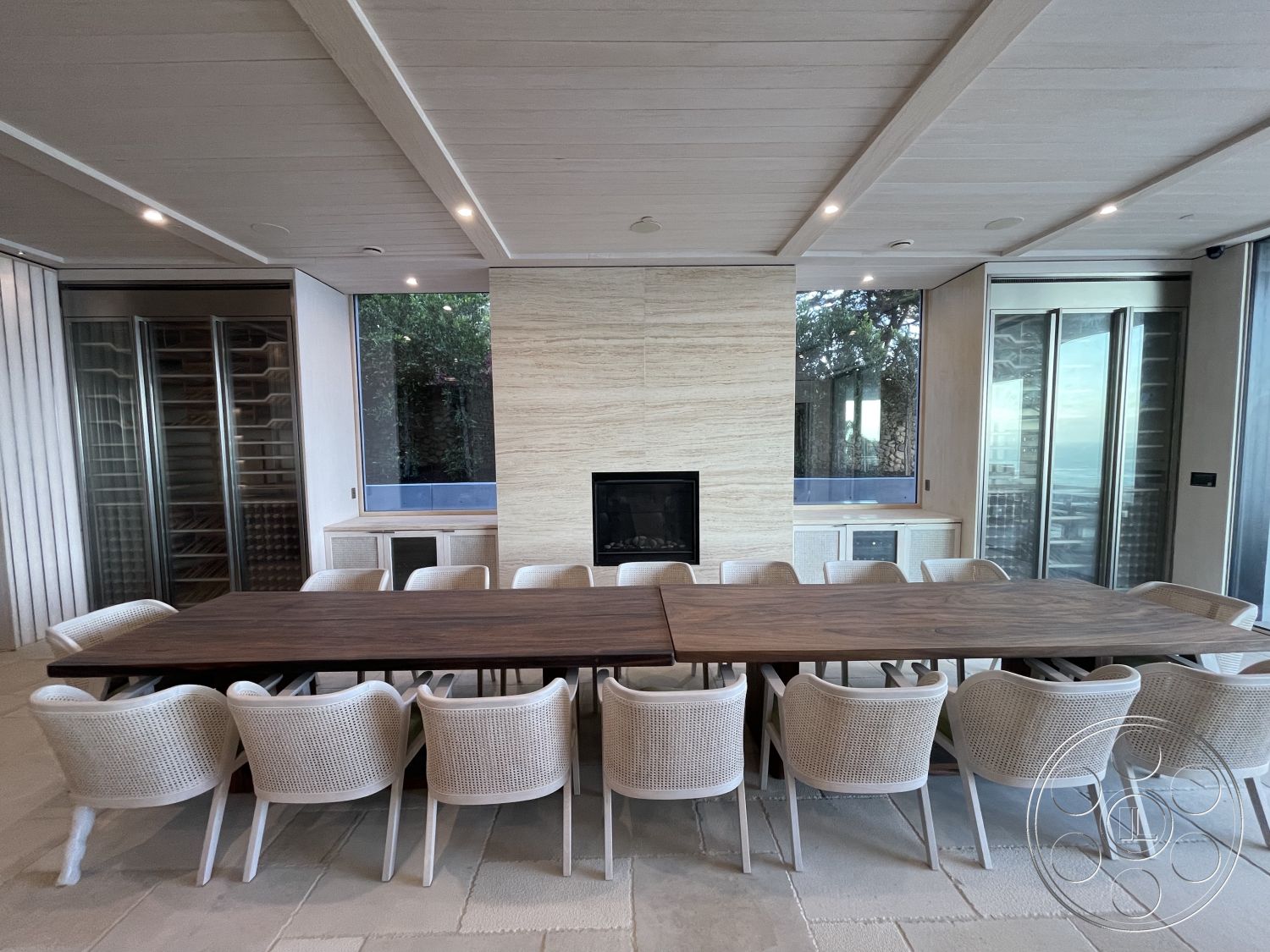 Modern 509 - neutral color palette, concrete flooring, open concept layout, wood dining table, floor-to-ceiling windows, white woven dining chairs, contemporary design elements, city skyline view, casual dining environment, exposed wood ceiling beams, interior dining area, modern kitchen cabinetry, natural light ambiance, textured stone fireplace wall